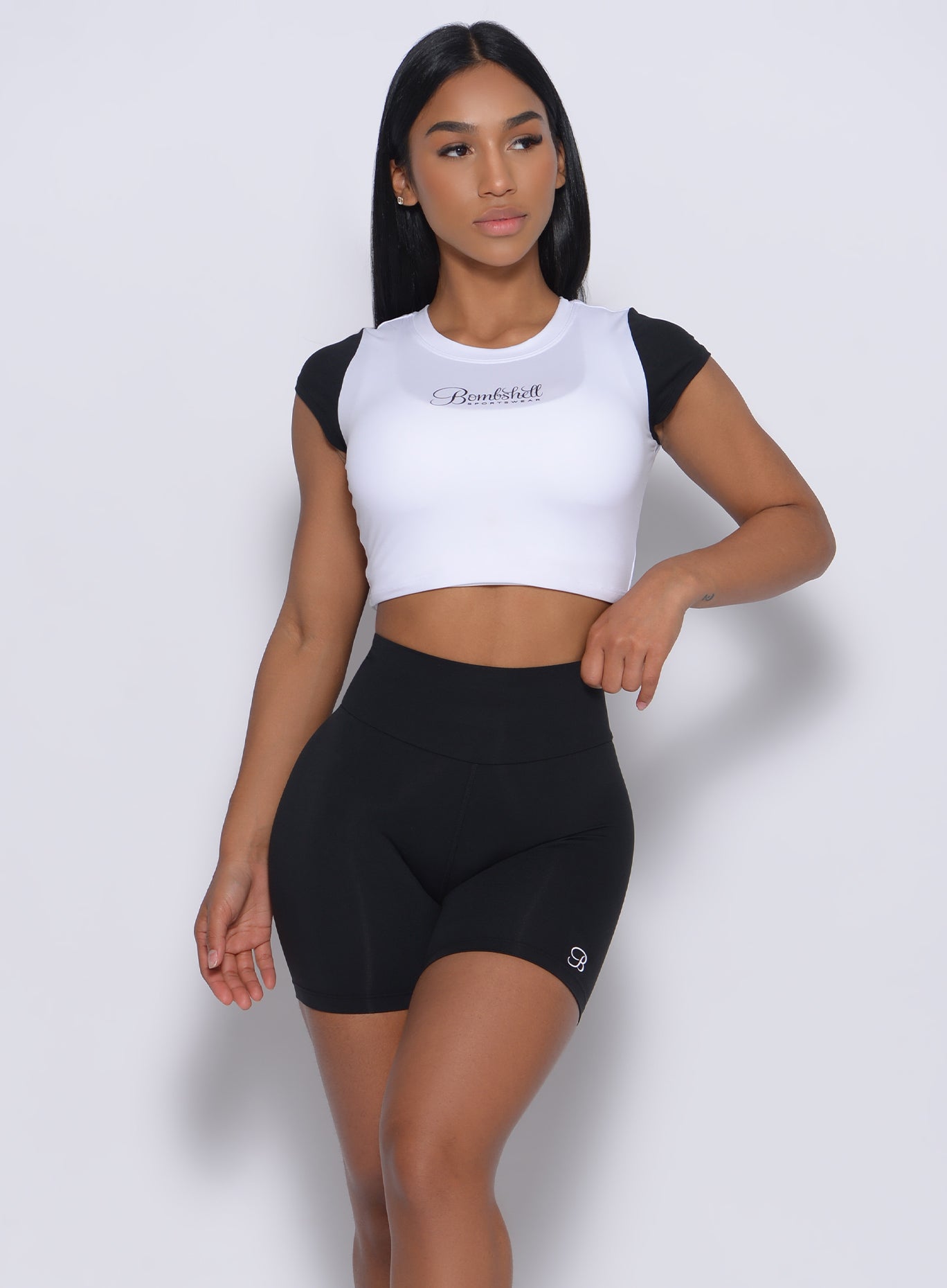 Front profile view of a model in our black white crop fit fam tee and a matching black shorts 