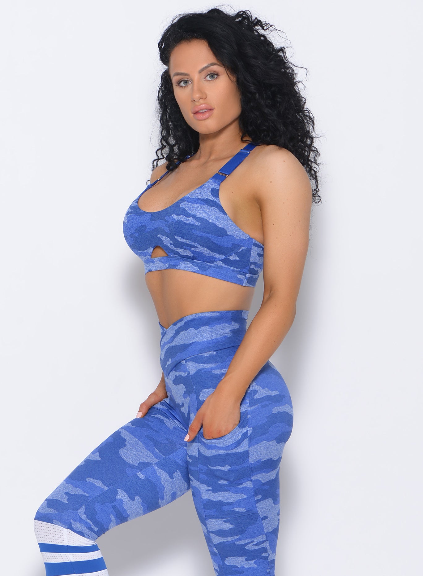Left side view of the model wearing our blue fit camo sports bra and a matching leggings