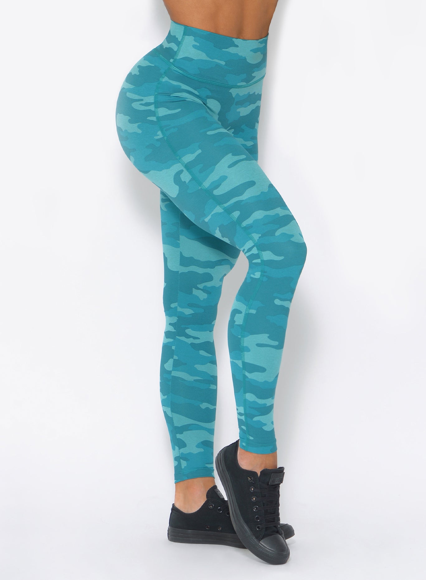 Zoomed in view of the model wearing our fit camo leggings in teal color