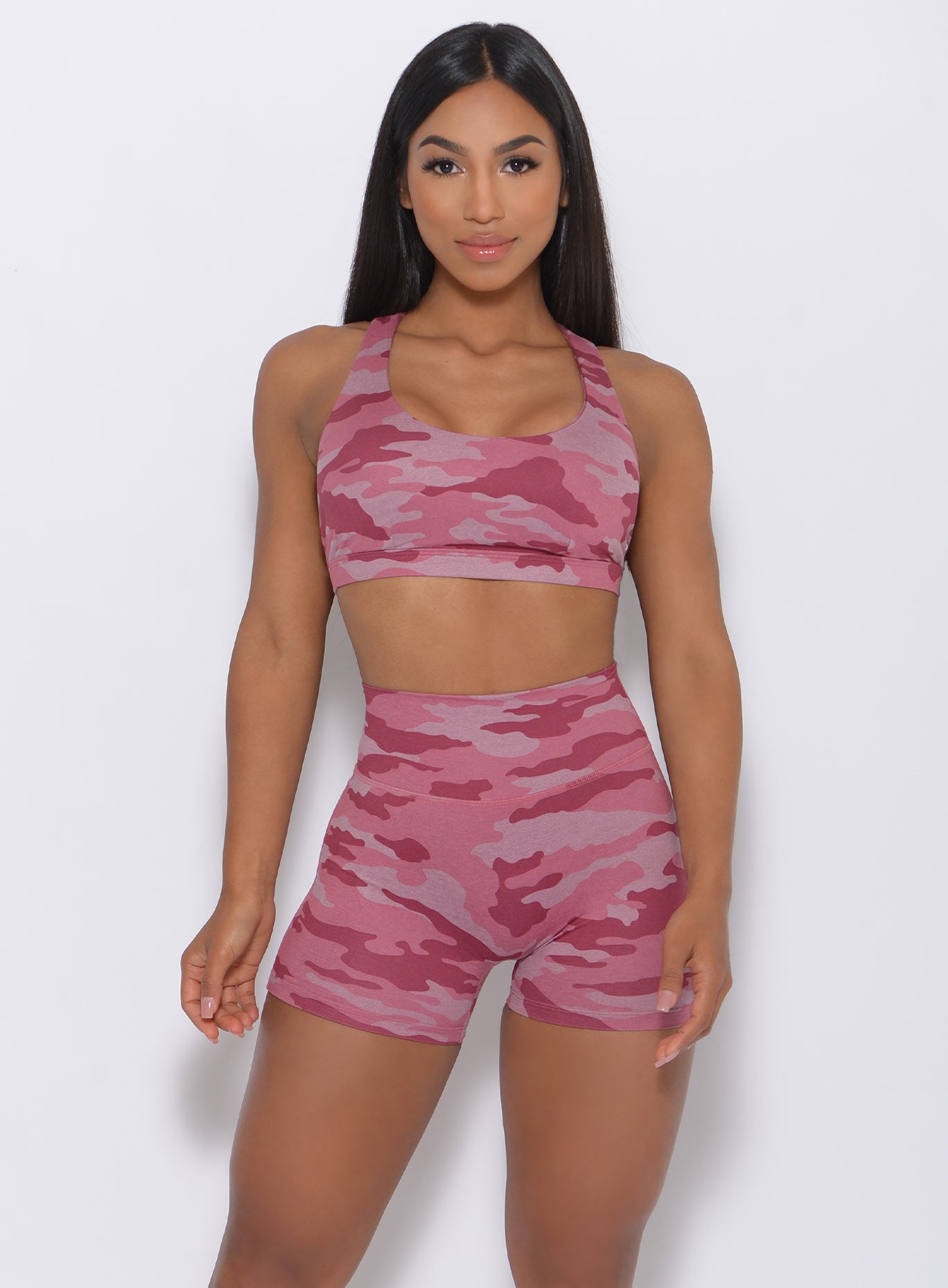 Front view of the model  wearing our Fit Camo Shorts in hibiscus camo color and a matching bra 