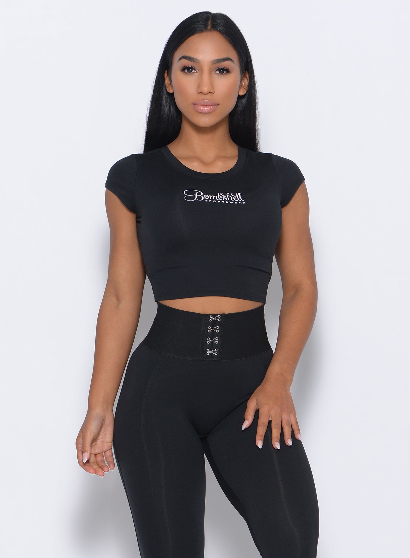 Front profile of the model in our black fit fam tee and a matching leggings 