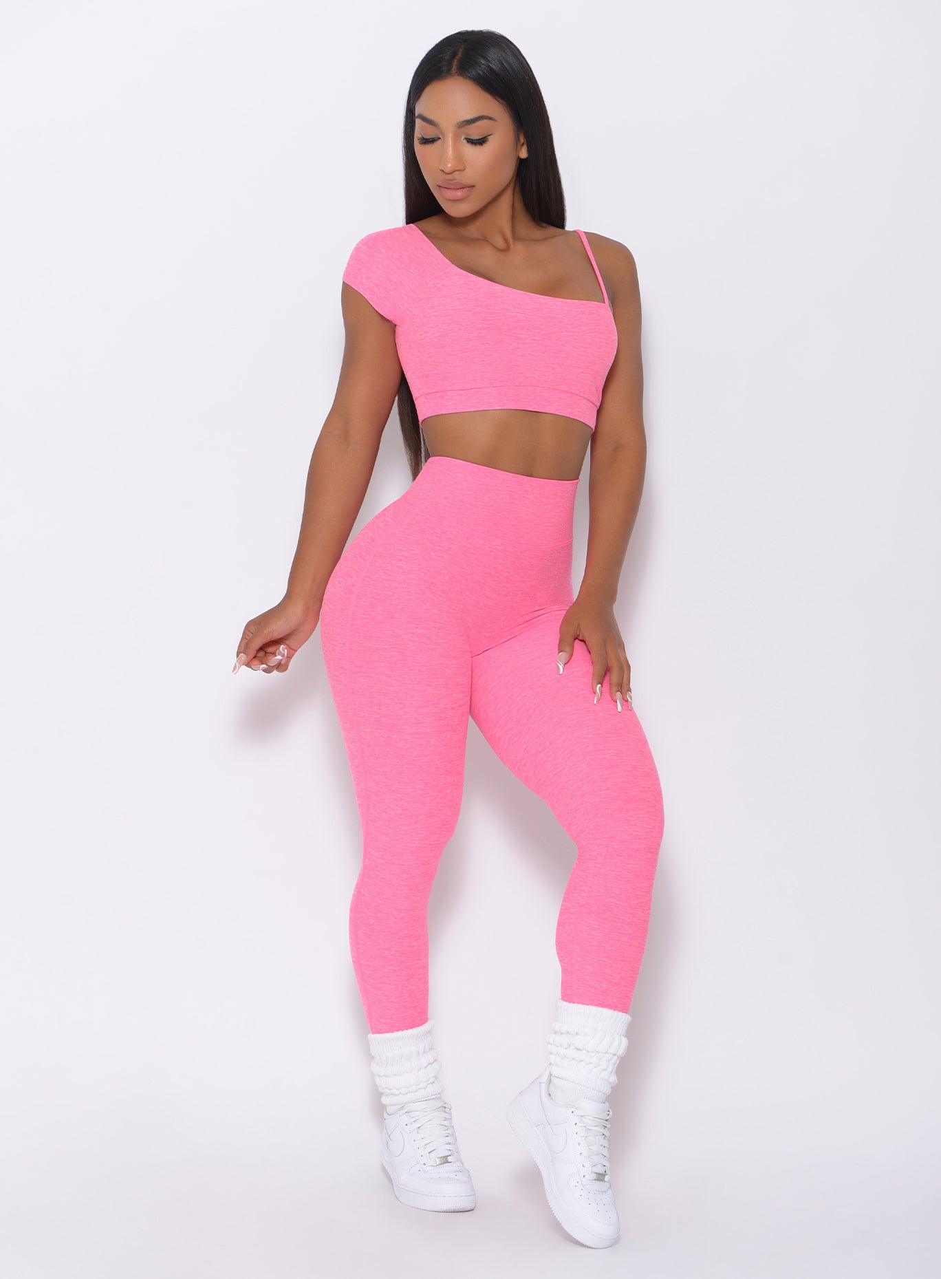 Front profile view of the model in our pink fit leggings and a matching top