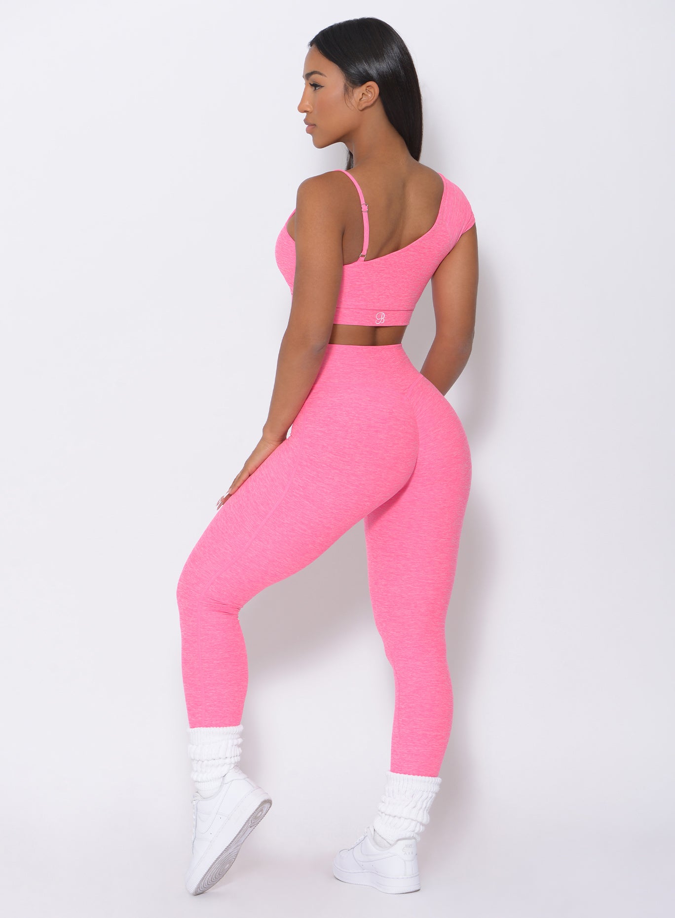 Back view of the model in our pink fit leggings and a matching top