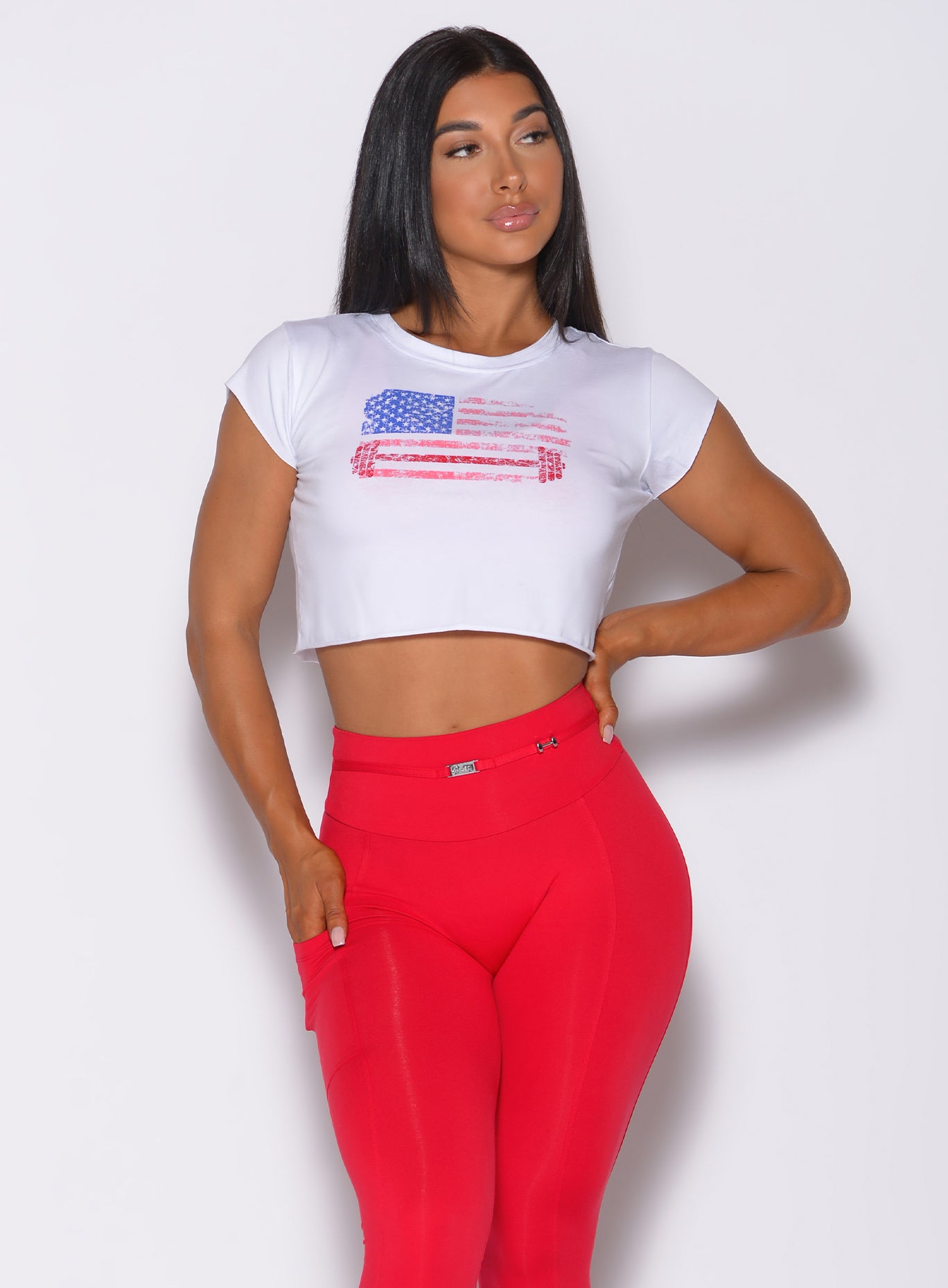 Front profile view of a model in our white USA Barbell tee and a red leggings 