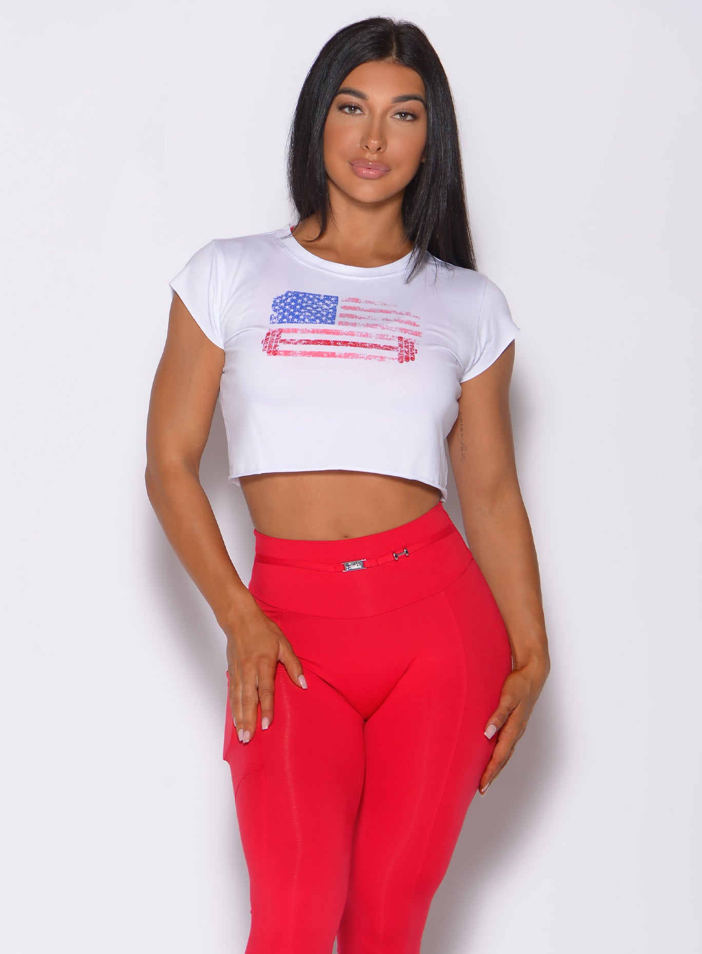 Model facing forward wearing our white USA barbell leggings and a red high waist leggings 