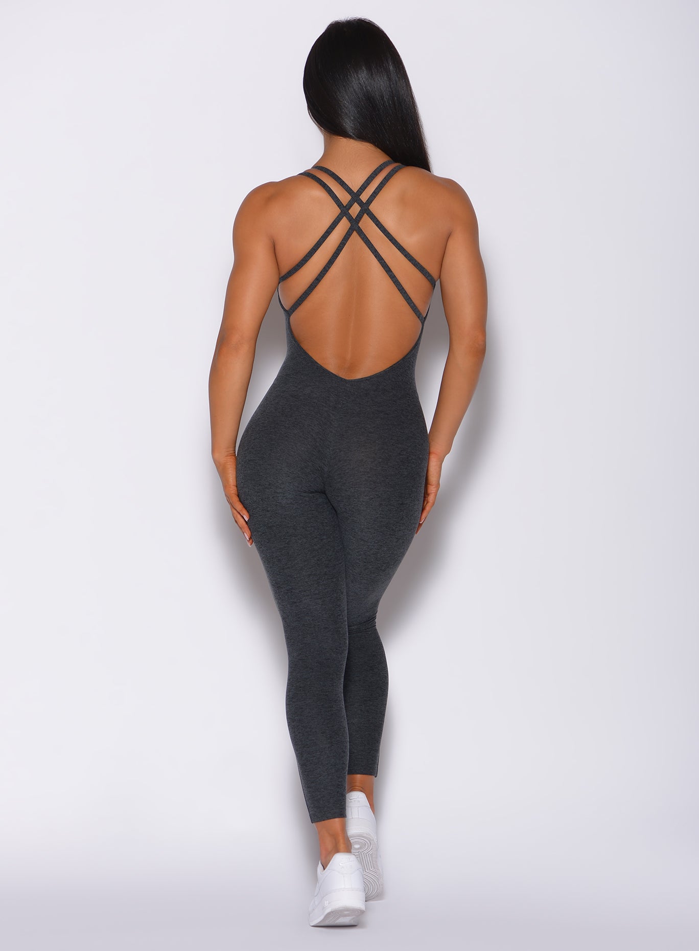 Back profile view of a model in our form bodysuit in charcoal color 