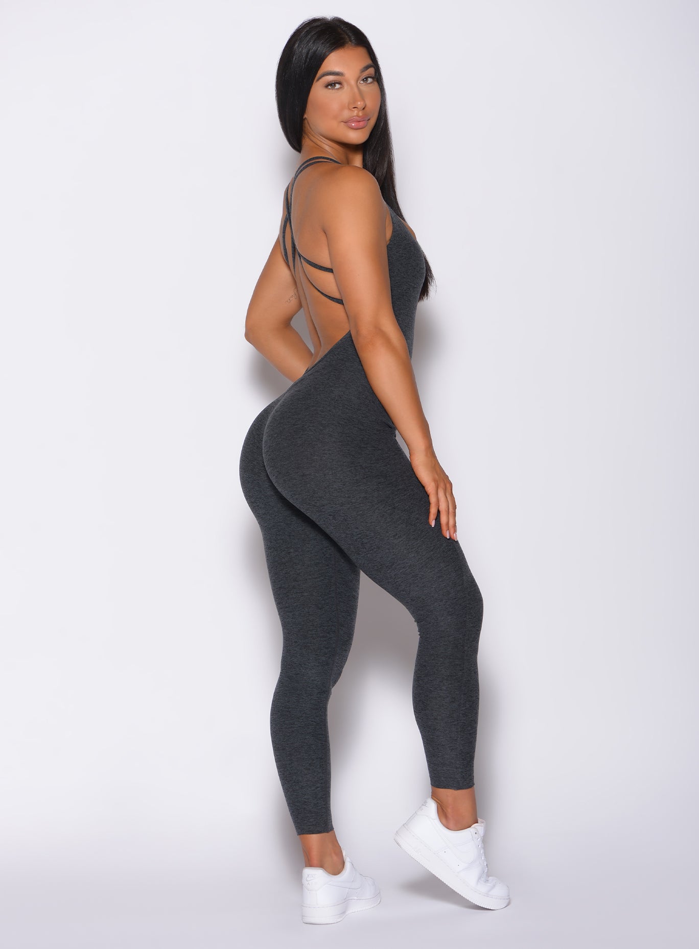 Right side profile view of a model in our form bodysuit in charcoal color 