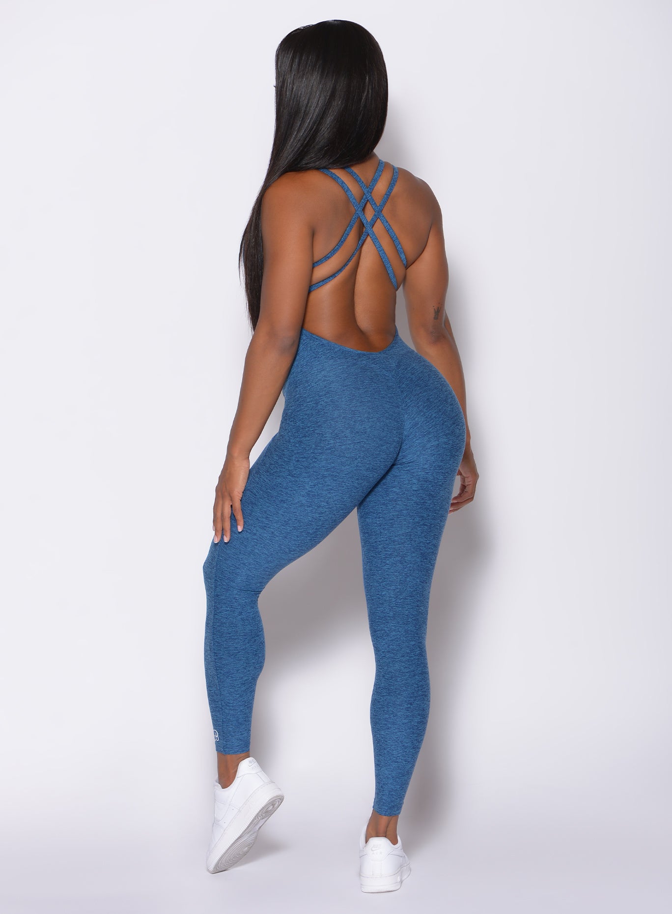 Back profile picture of a model wearing our form bodysuit in  ocean color 