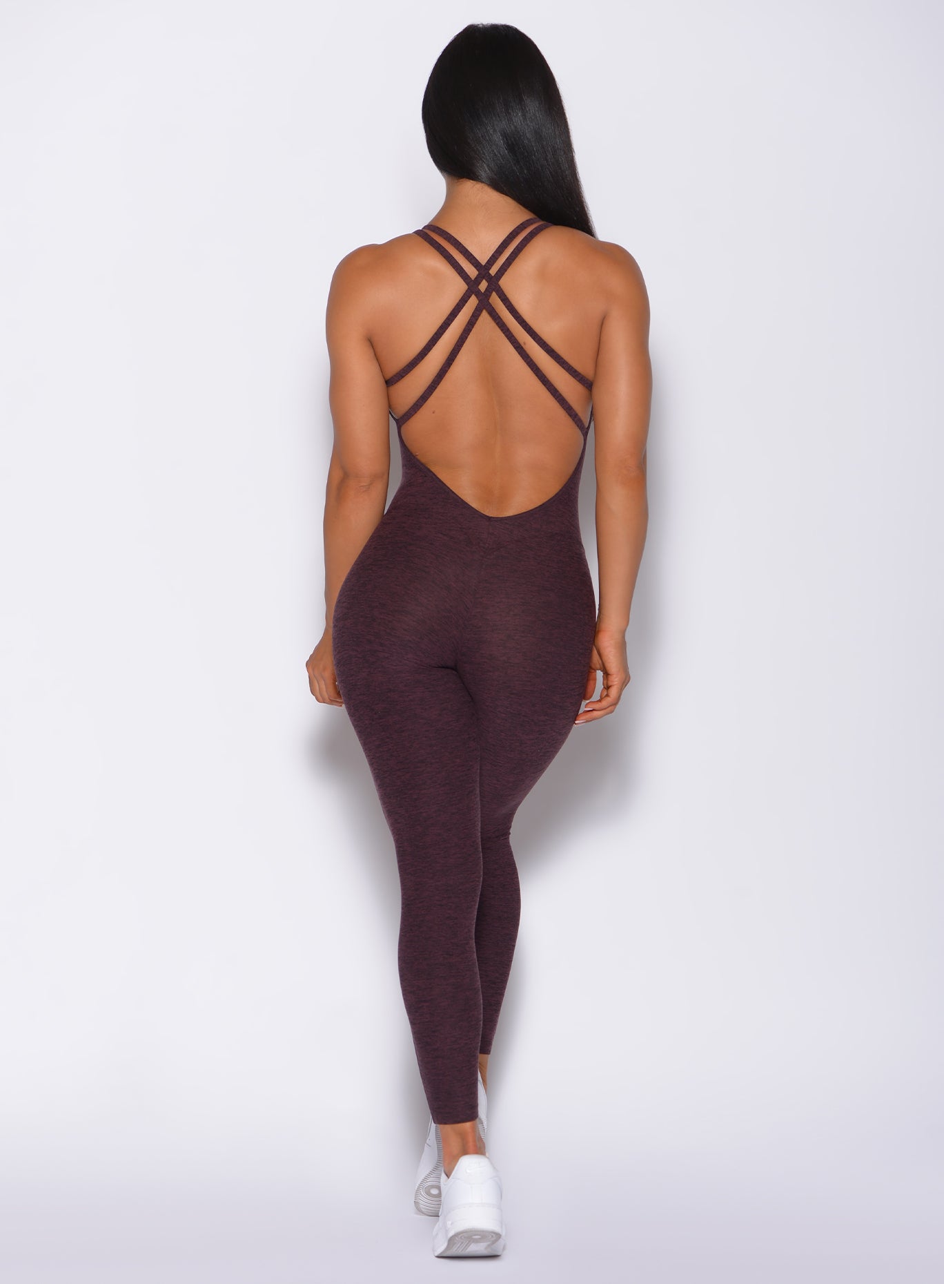 Back profile view of a model in our form bodysuit in port color