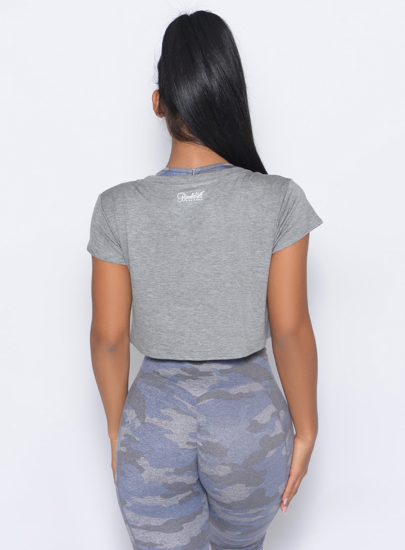 Back view of the model in our freedom tee in silver color and a matching leggings
