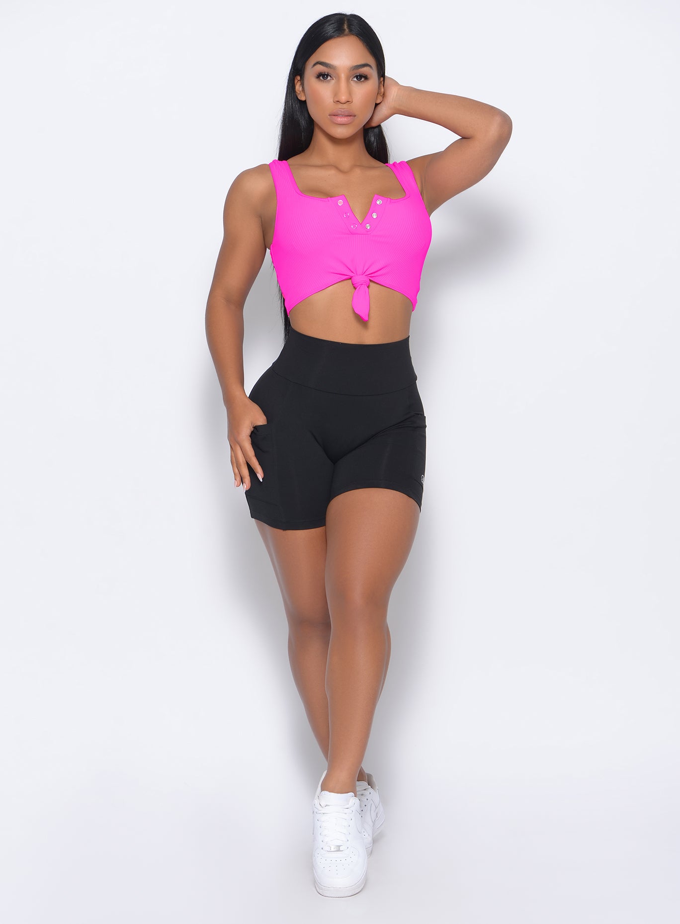 Front profile picture of the model wearing our black pocket biker shorts and a neon pink bra