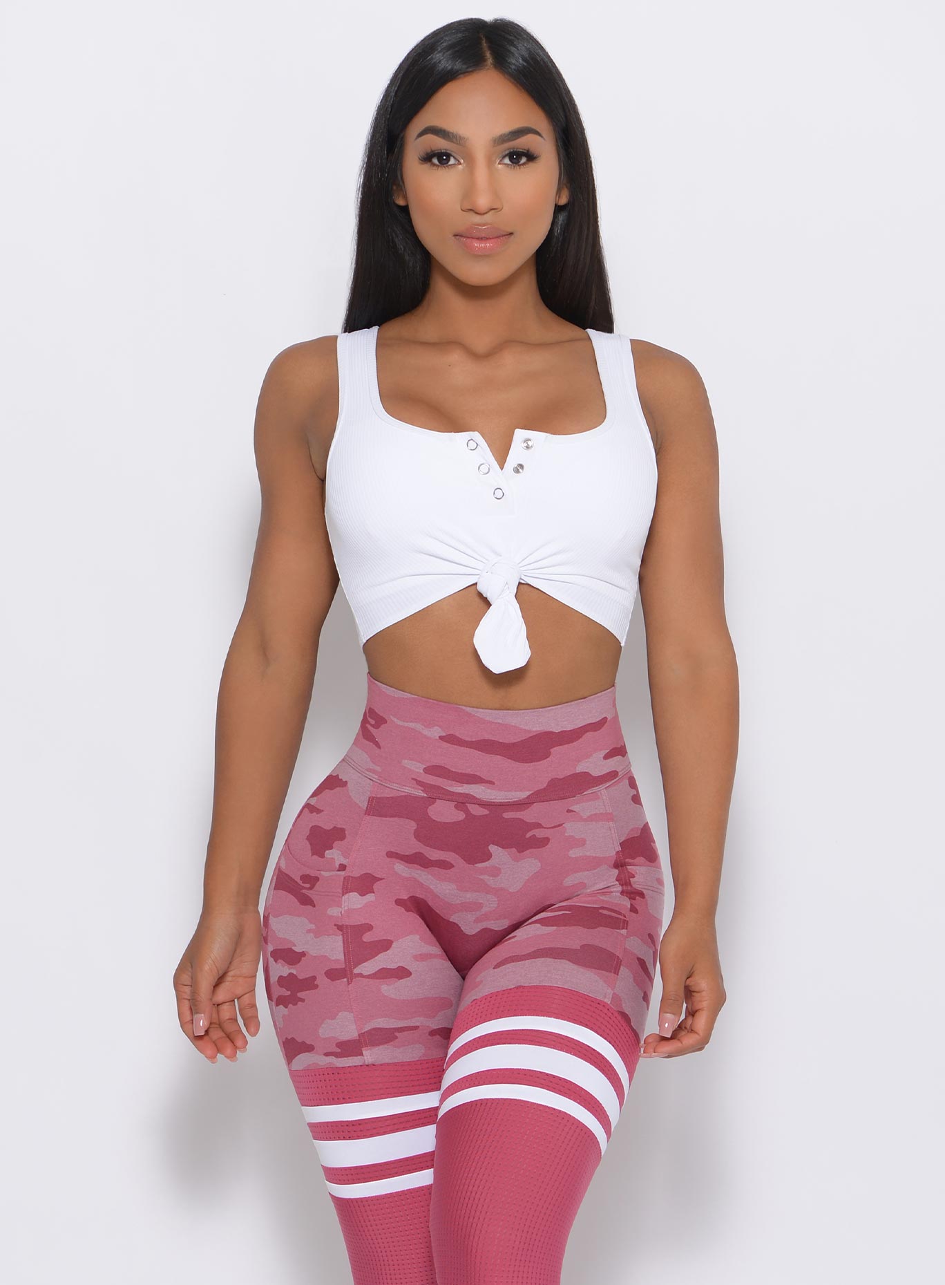 Model facing forward wearing our white Henley Sports Bra and a matching leggings 