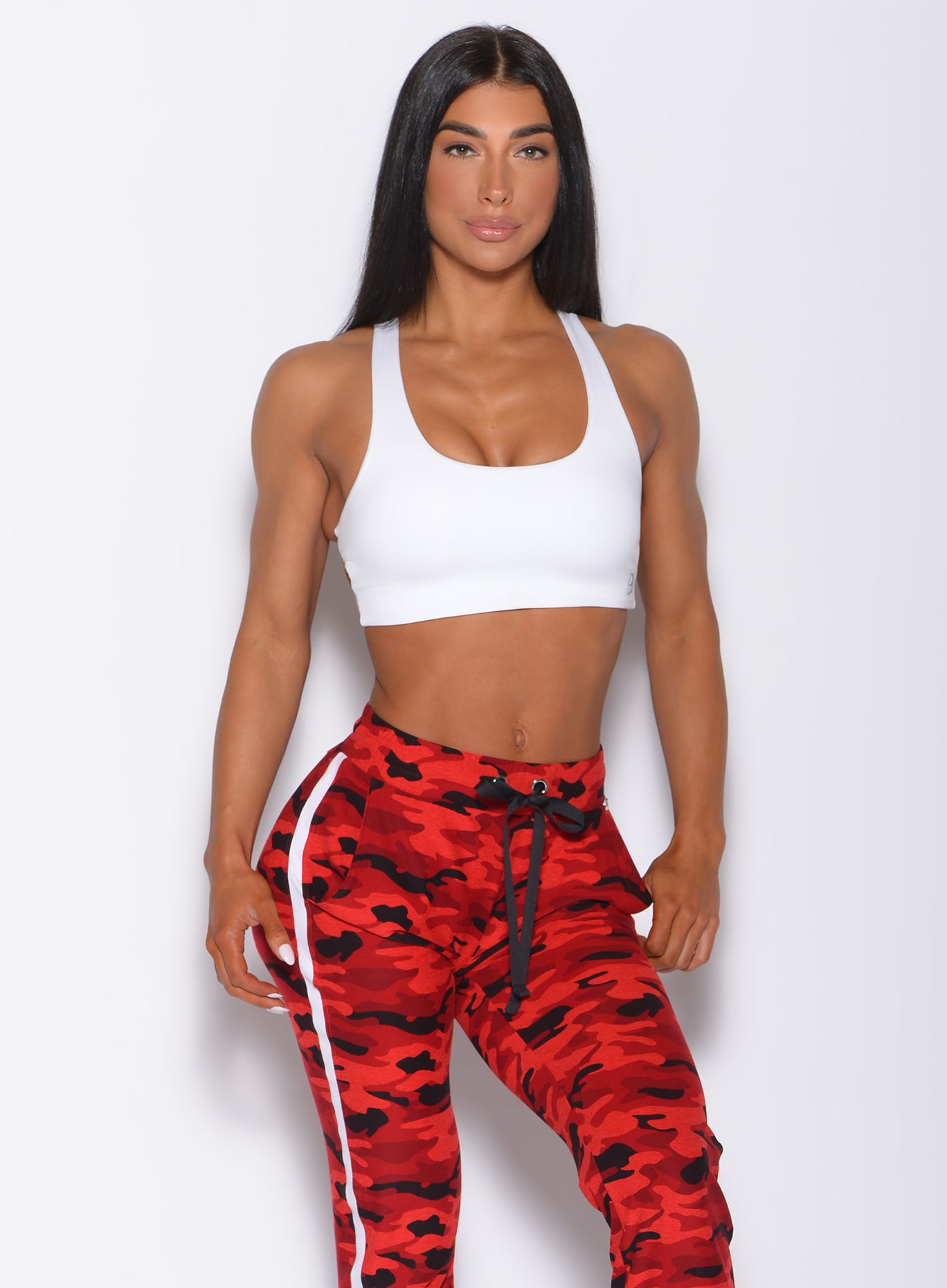 Front profile view of a model wearing our white back it up bra and a red camo joggers