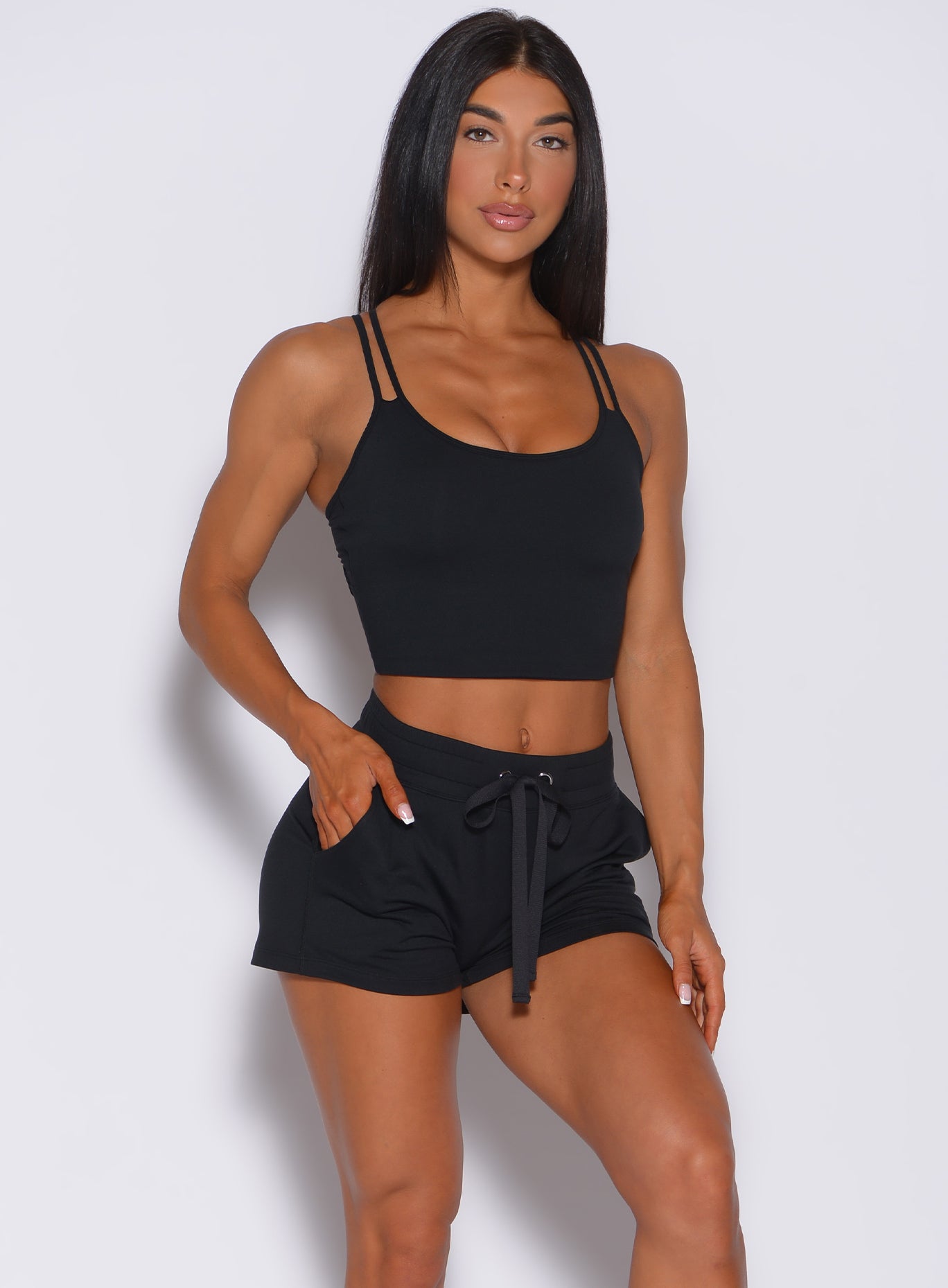 Front profile view of a model in our black layered back bra and a matching shorts