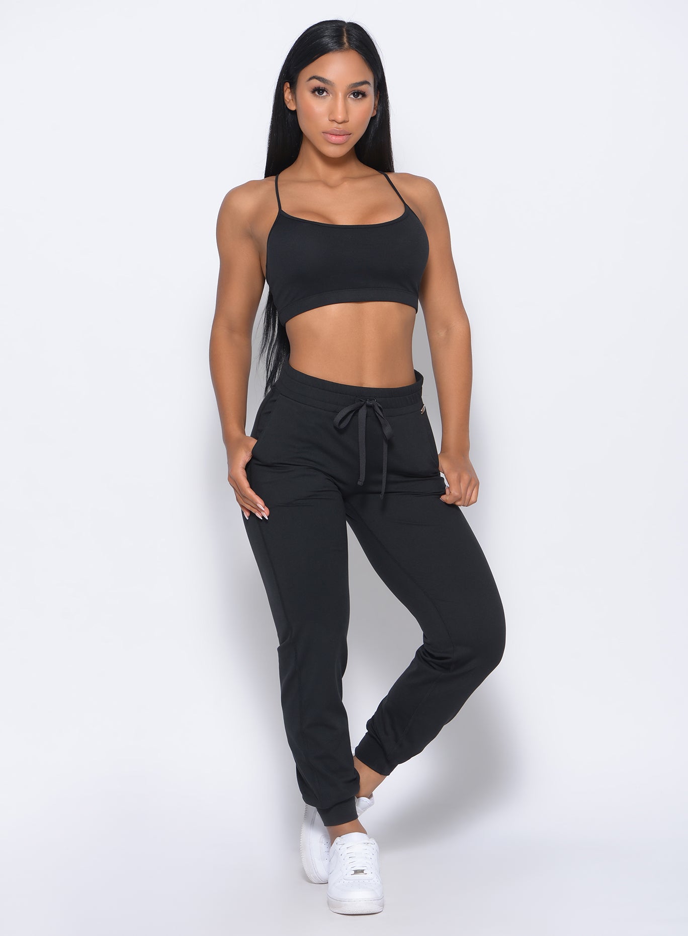 Model facing forward wearing our black Relax Sports Bra and a matching joggers