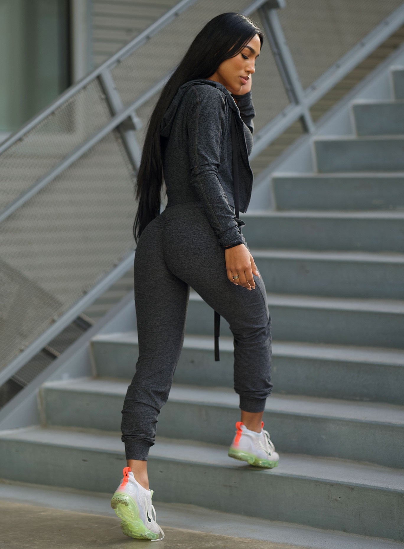 Right side view of the model in our cozy zip hoodie in charcoal color and a matching joggers