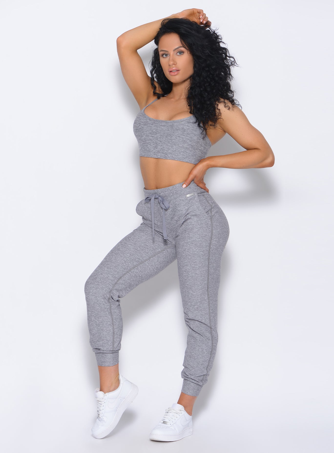 Picture of a model with her right hand over her head wearing our Relax Sports Bra in cloud color and a matching joggers
