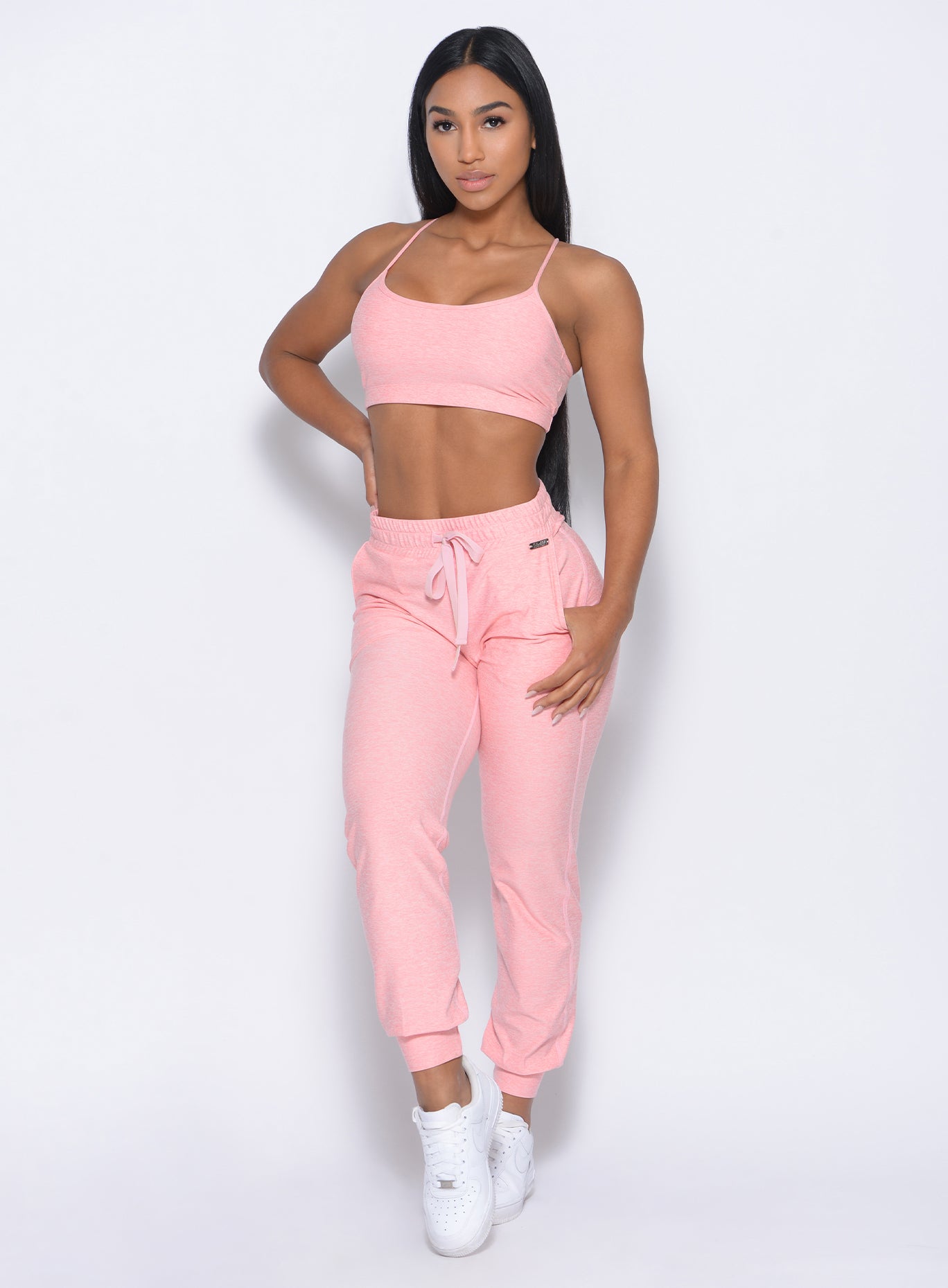 Front profile of the model in our cozy joggers in peachy pink and a matching bra 