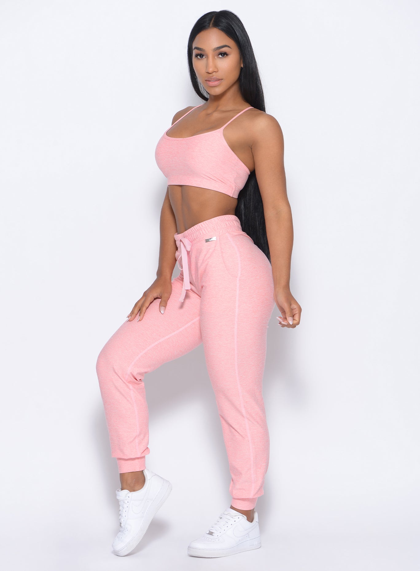 Left side view of the model angled left wearing our cozy joggers in peachy pink and a matching hoodie