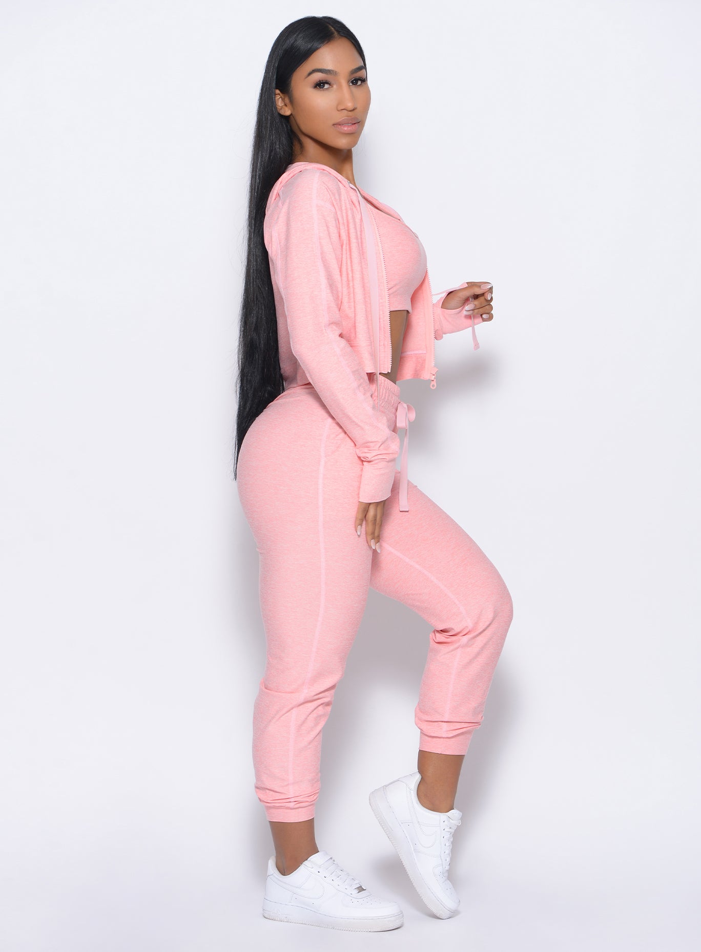 Right side view of the model in our cozy joggers in peachy pink and a matching hoodie 