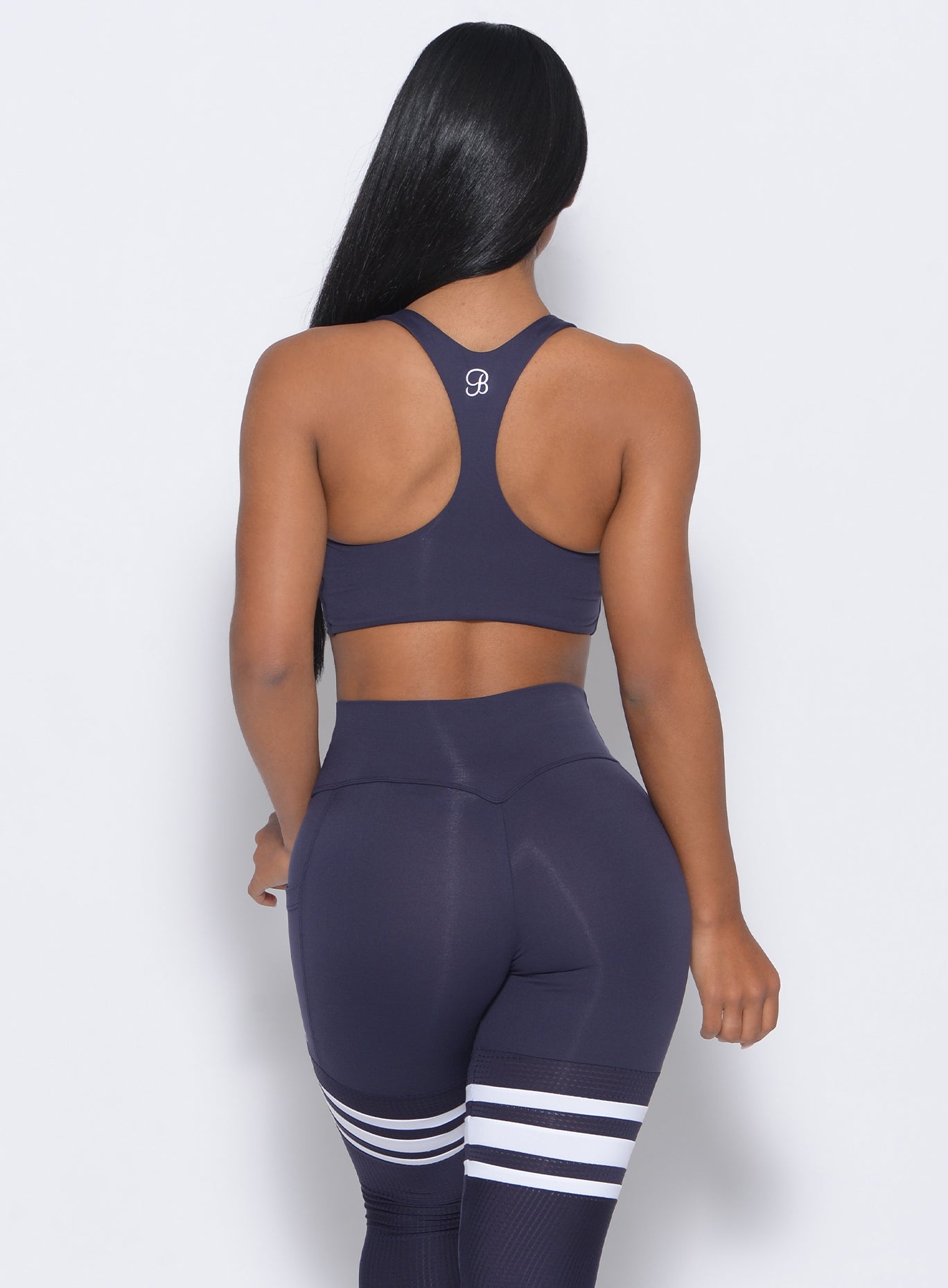 back view of the model in our keyhole bralette in twilight blue color and a matching leggings