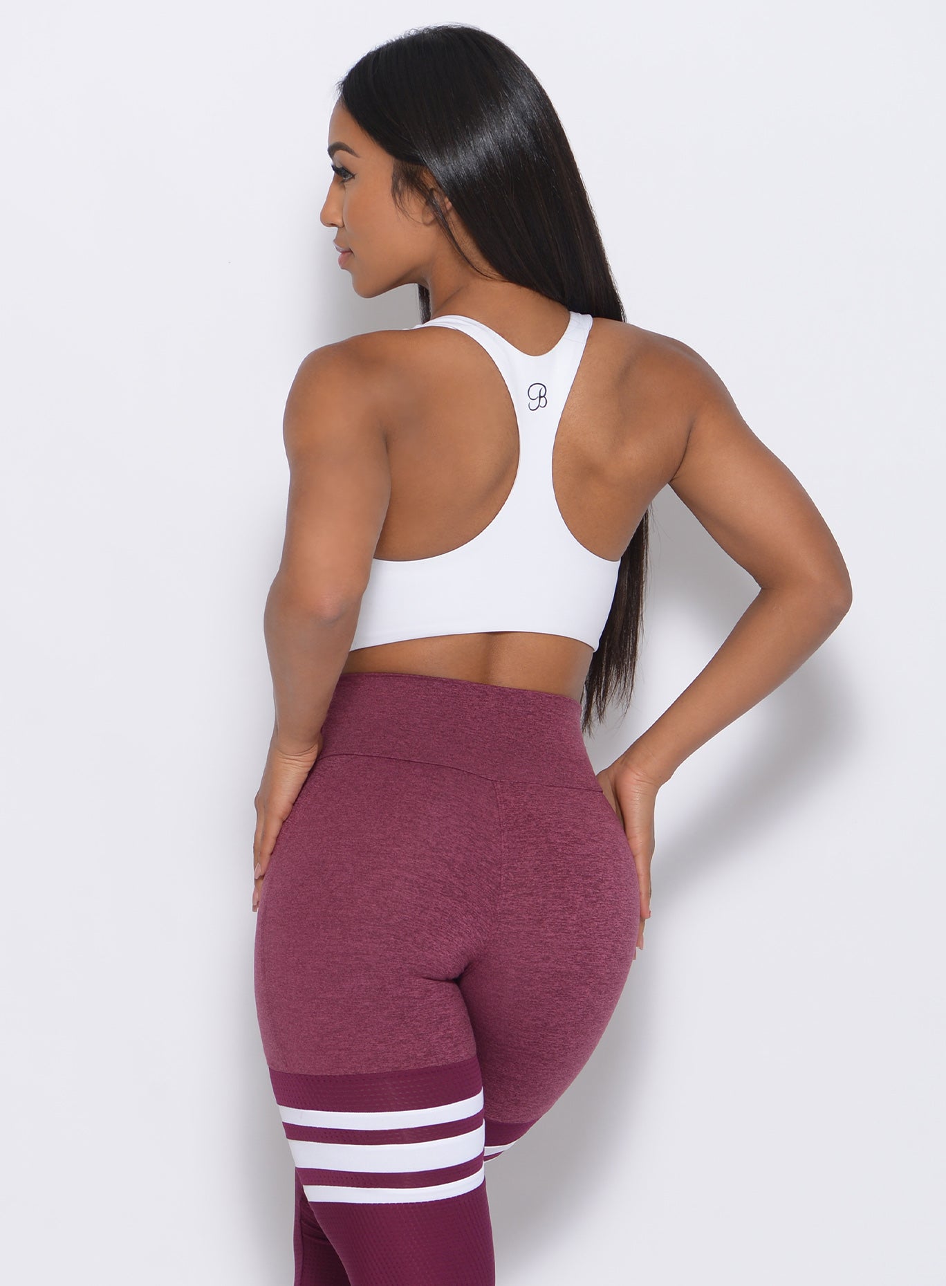 Back view of the model wearing our white Bralette and a high waist leggings in Burgundy Rose