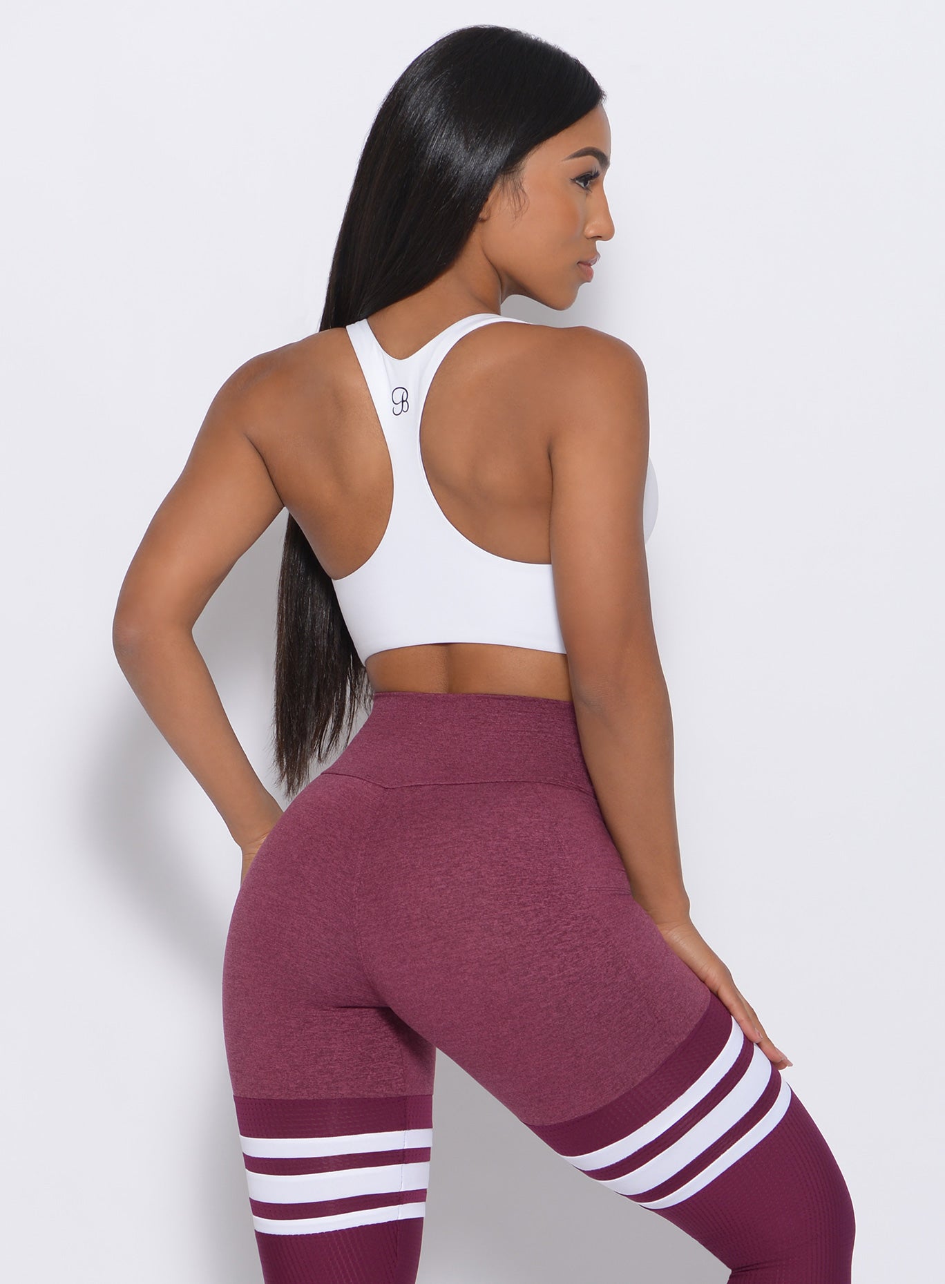 Back view of the model wearing our white Bralette and a high waist leggings in Burgundy Rose