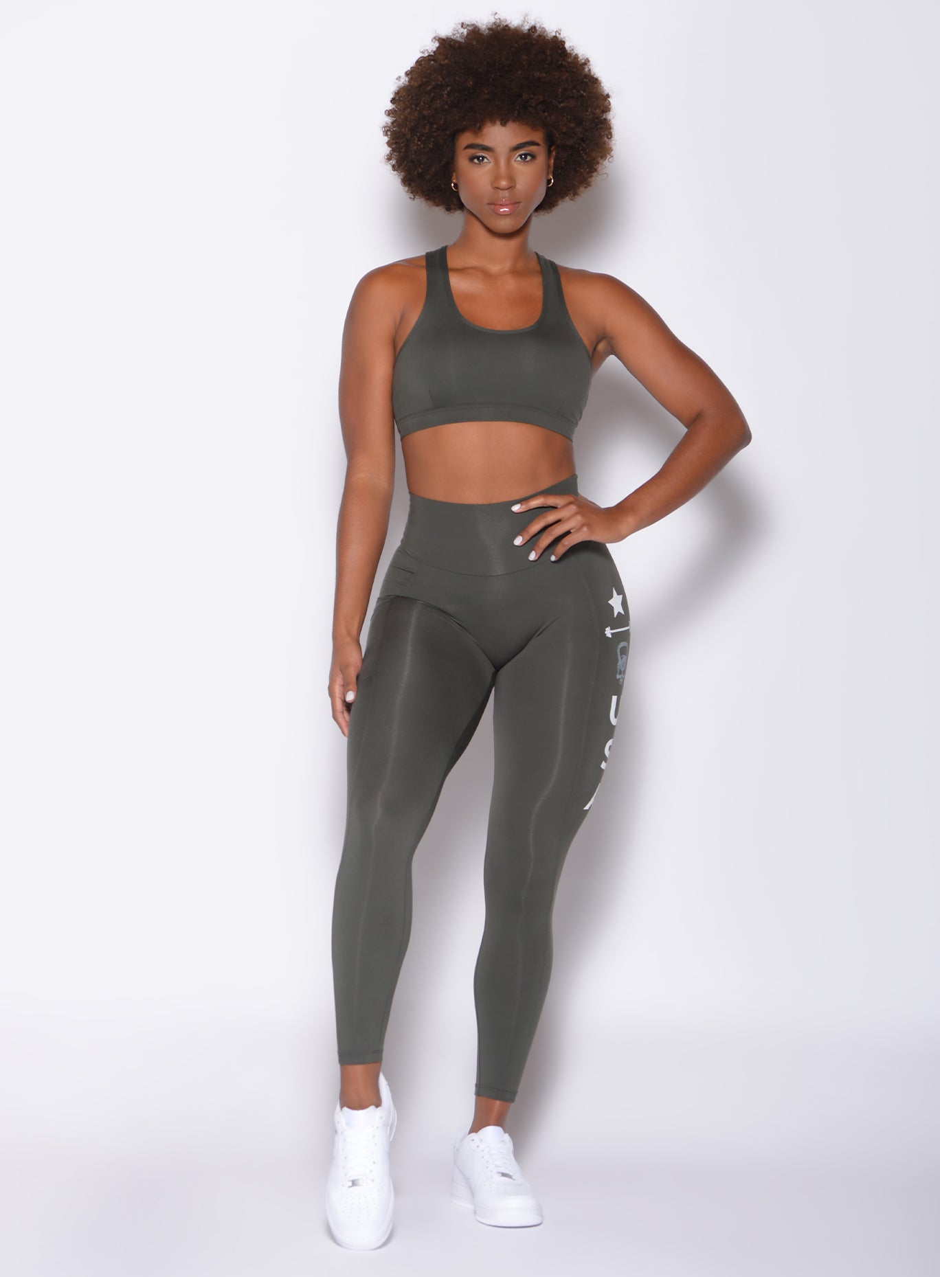 front view of model wearing our killing it leggings and scull crusher sports bra in hunter green