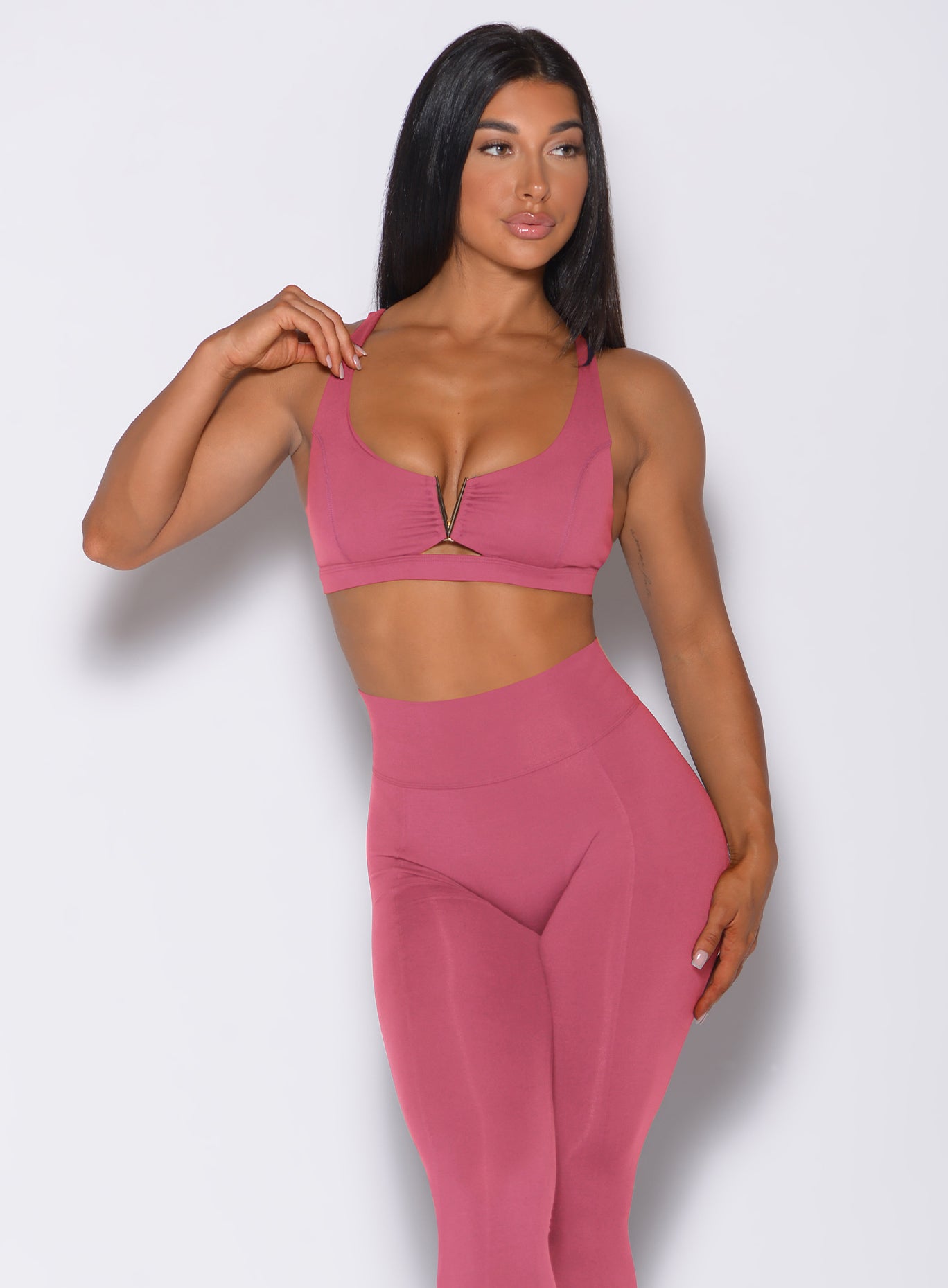 Front profile view of a model in our knockout sports bra in blush color and a matching leggings 