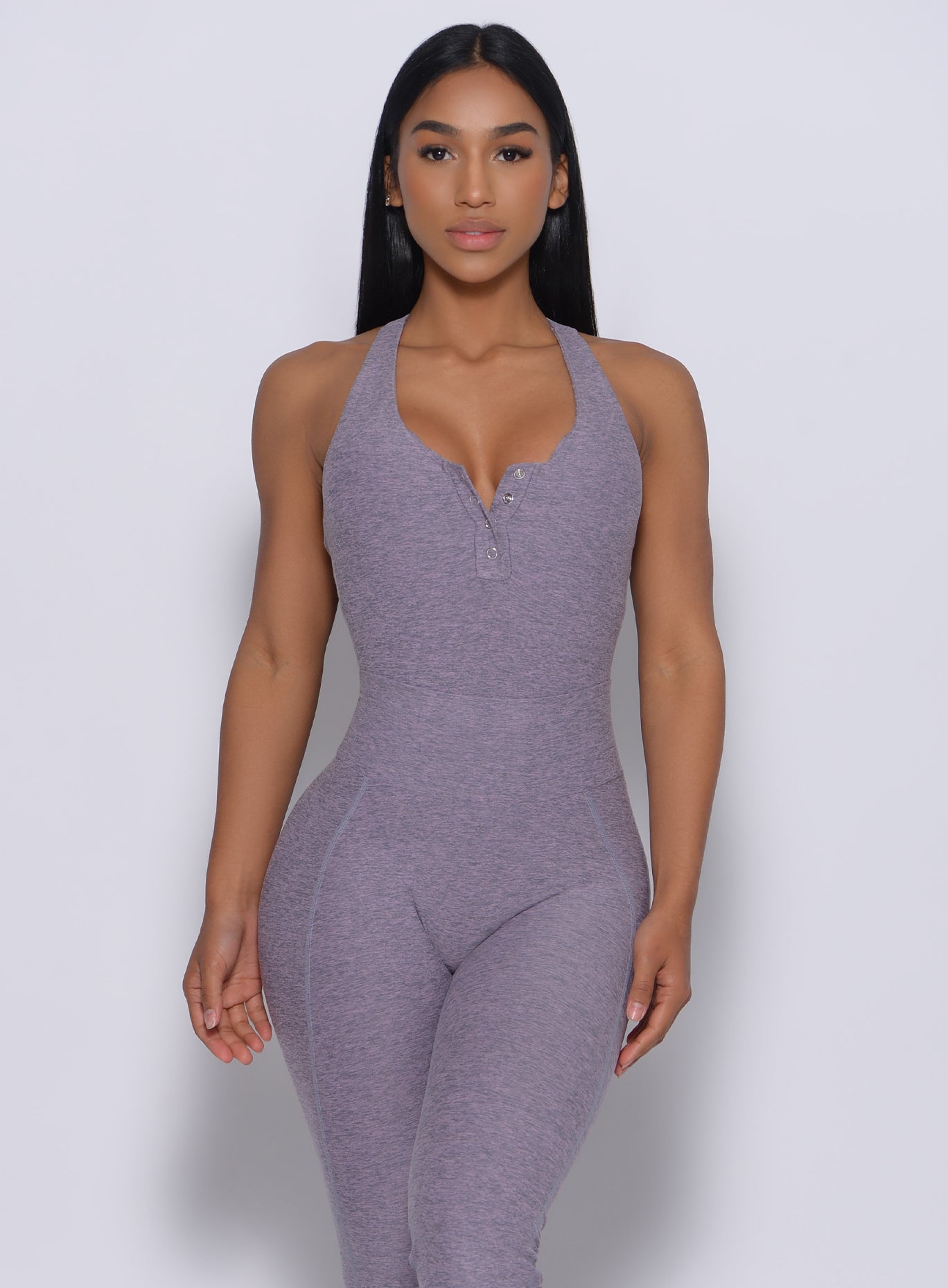 Front profile view of the model in our perfect bodysuit in orchid color and a matching leggings 