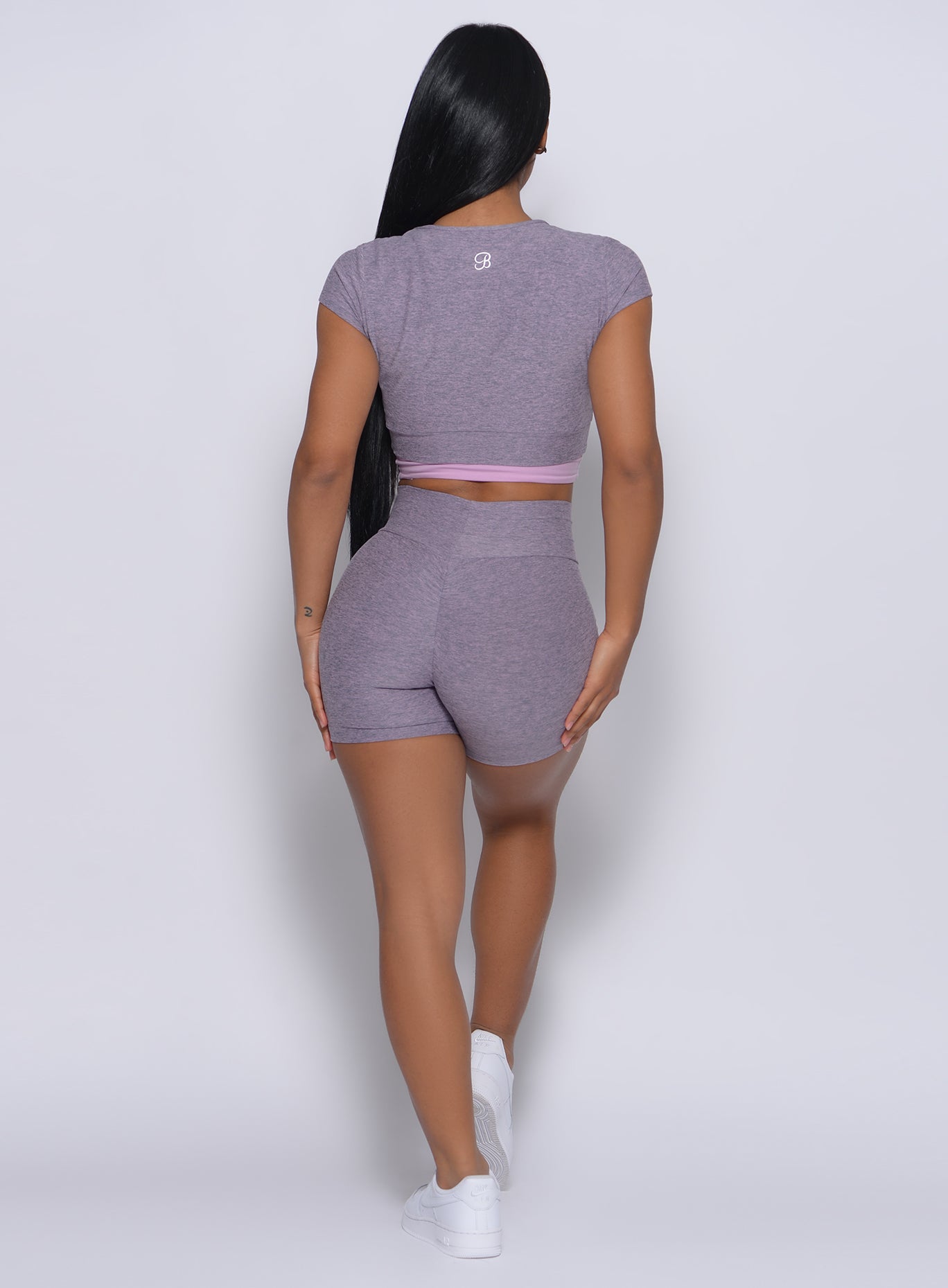 back profile view of a model in our straight up shorts in orchid color and a matching top