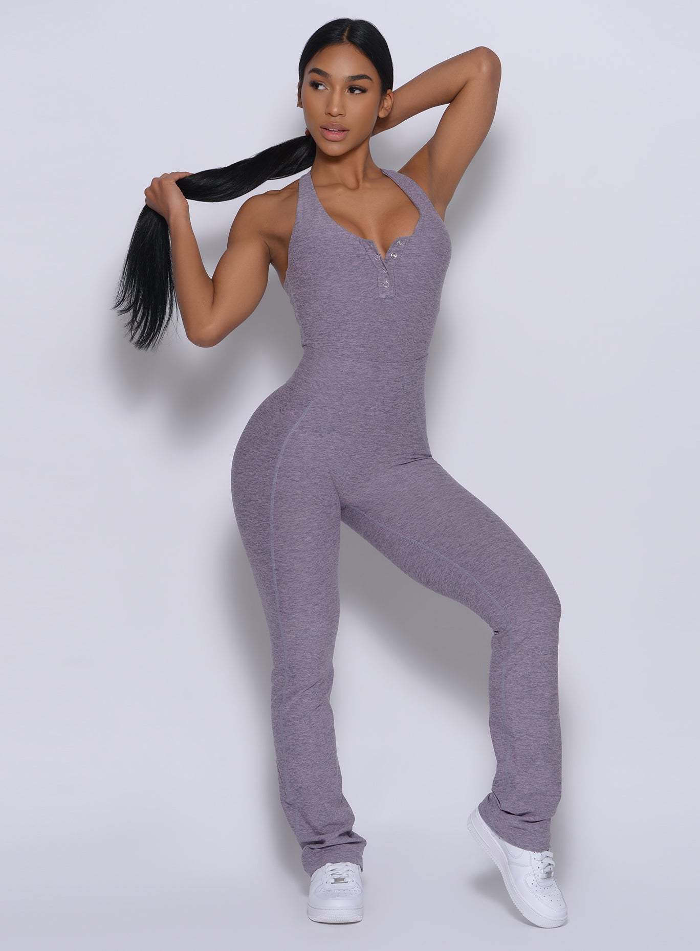 Front profile view of a model in our straight up leggings in orchid color and a matching bodysuit