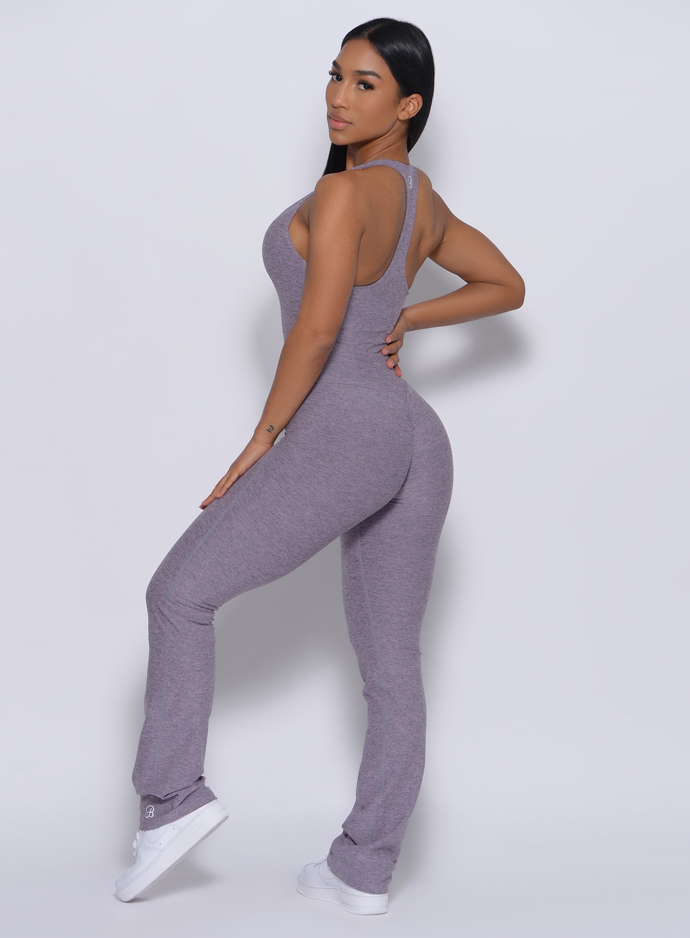 Left side profile view of a model in our straight up leggings in orchid color and a matching bodysuit