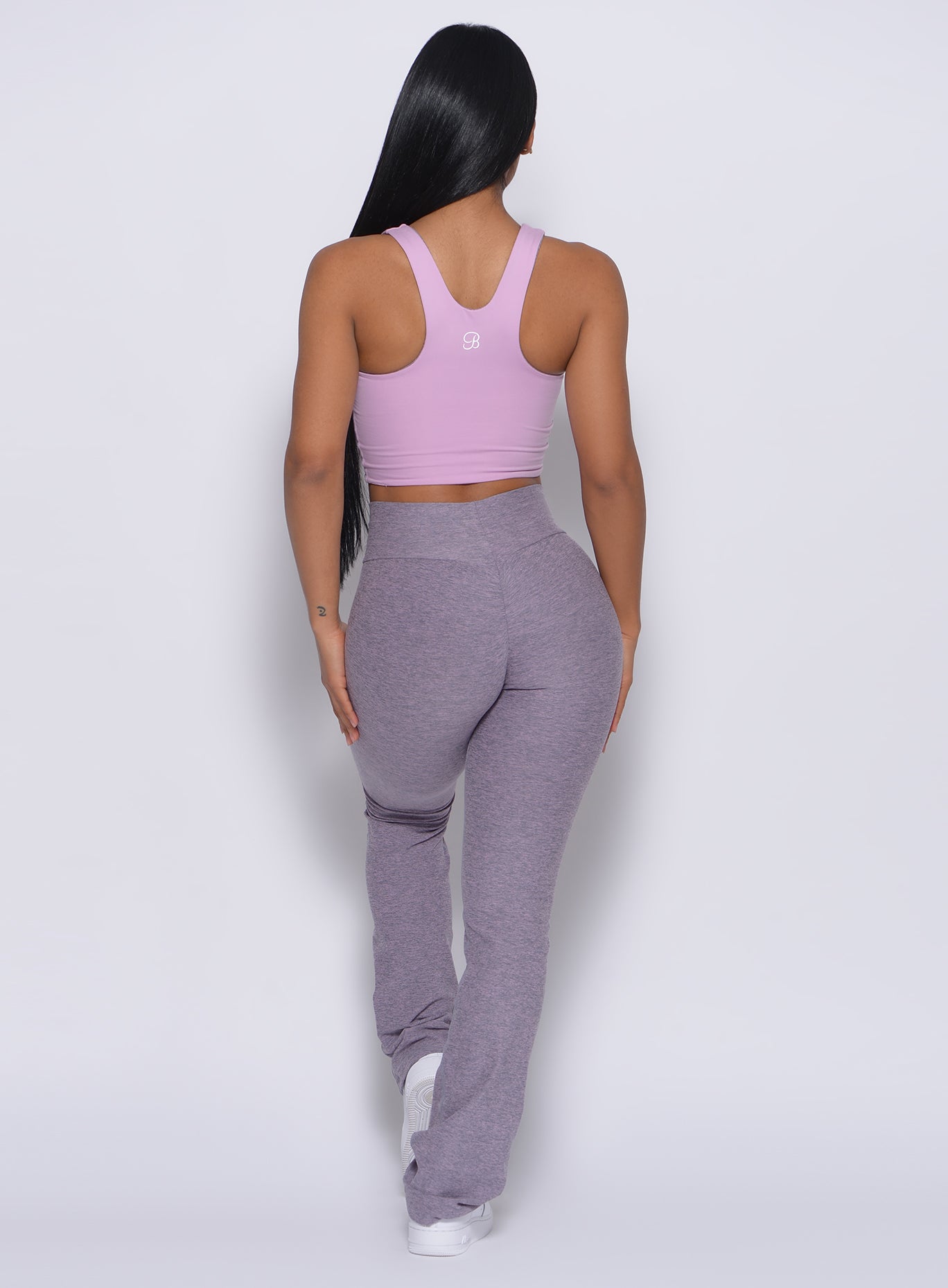 Back profile view of a model in our straight up leggings in orchid color and a blush bra 