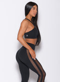 Right side profile view of a model in our black Attitude Sports Bra and a matching mohawk leggings
