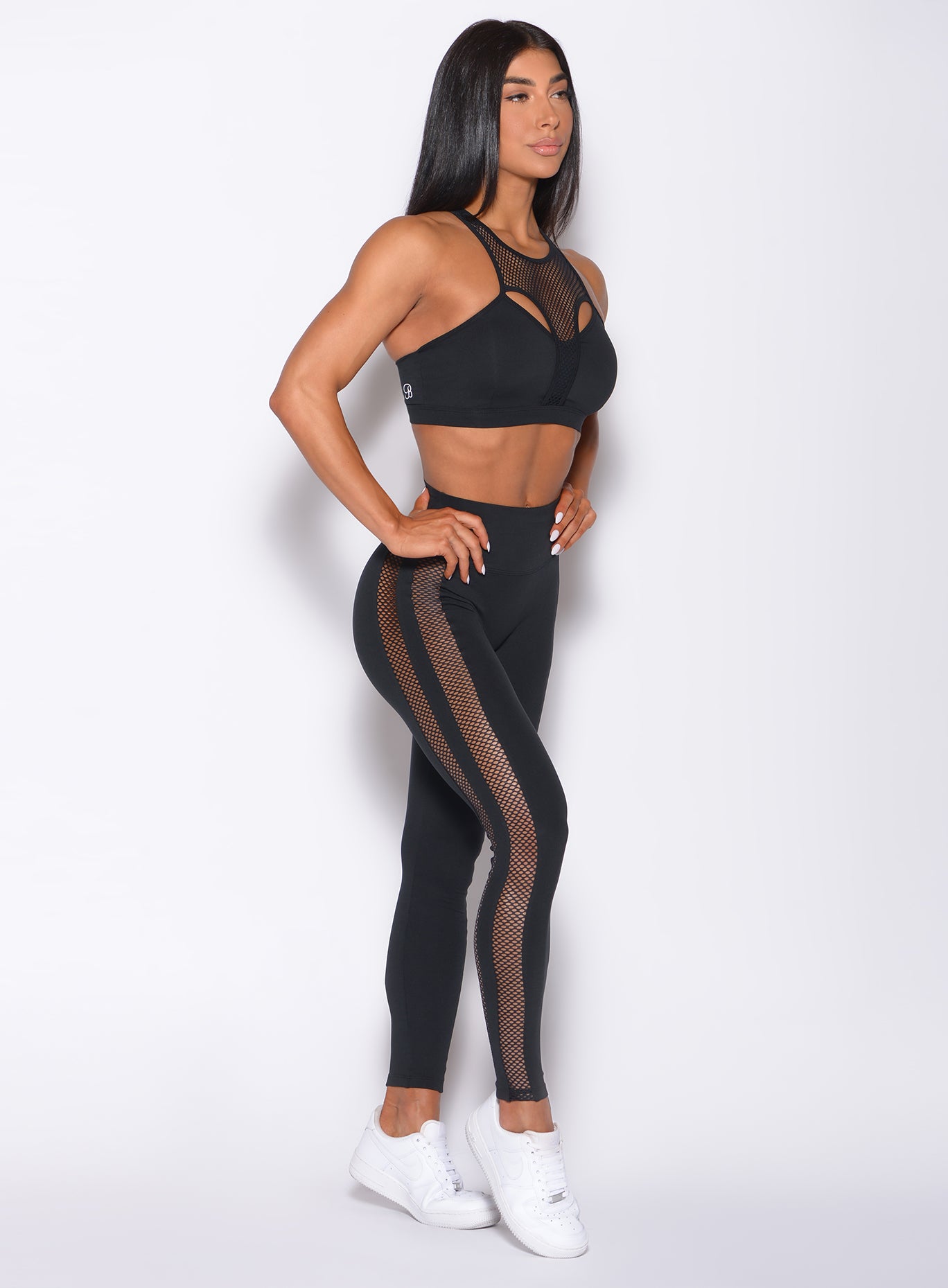 Right side profile view of a model in our black Mohawk leggings and a matching bra