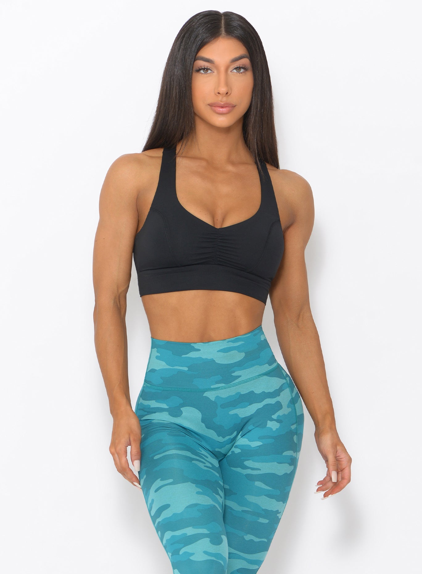 Front view of the model wearing our black mood sports bra and a high waist thigh high in teal color 