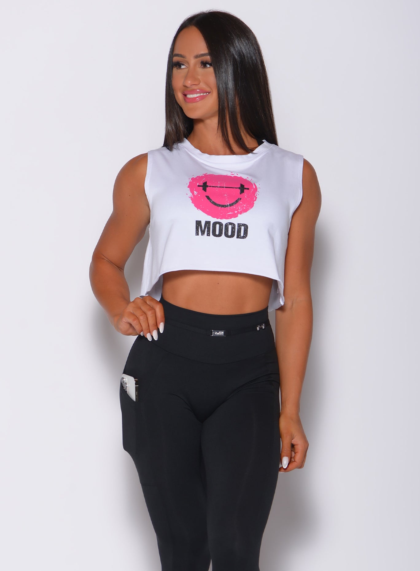 Front profile view of a model wearing our white mood tank and a black leggings