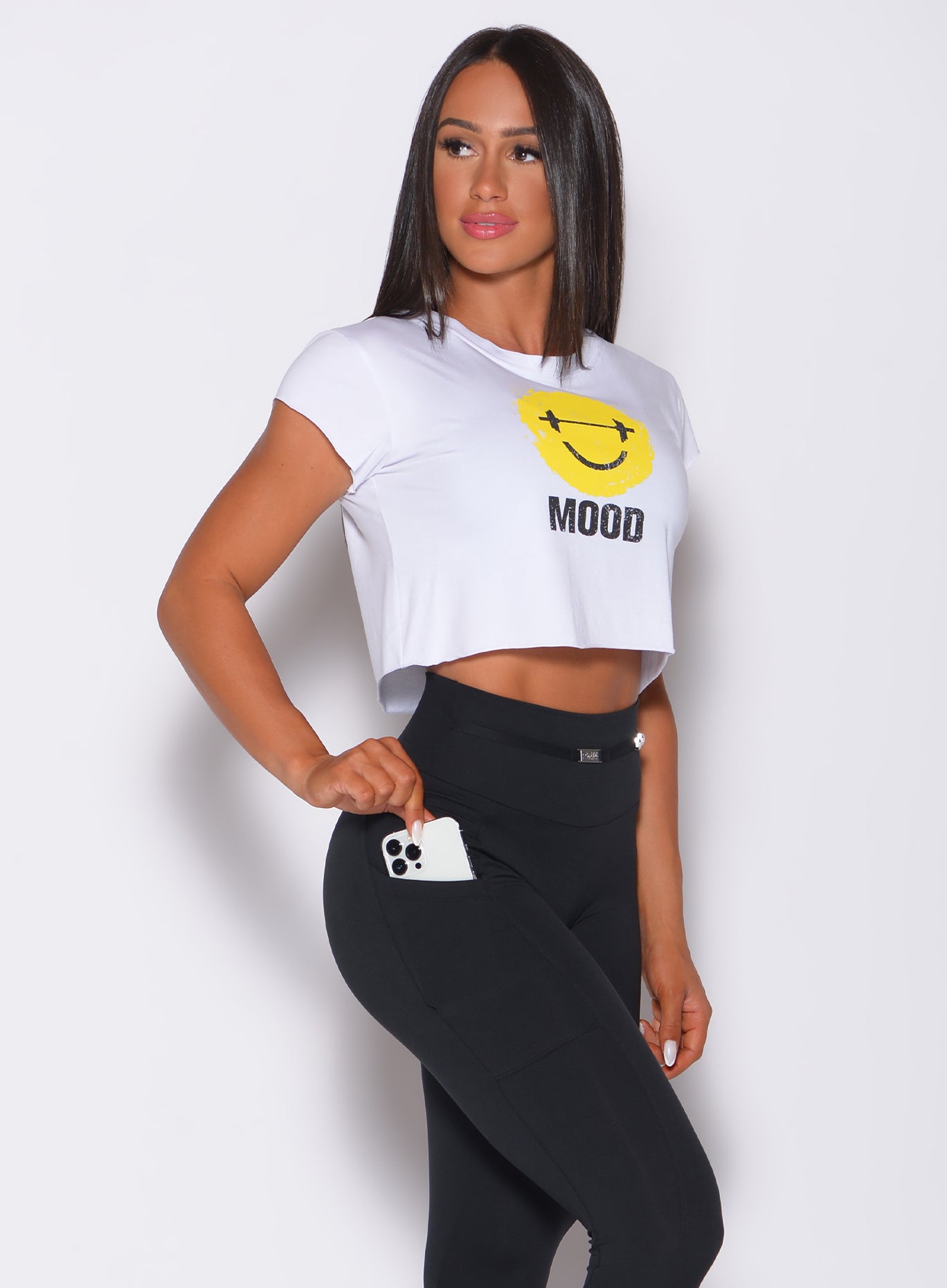 Right side profile view of a model angled right wearing our white mood tee and a black leggings