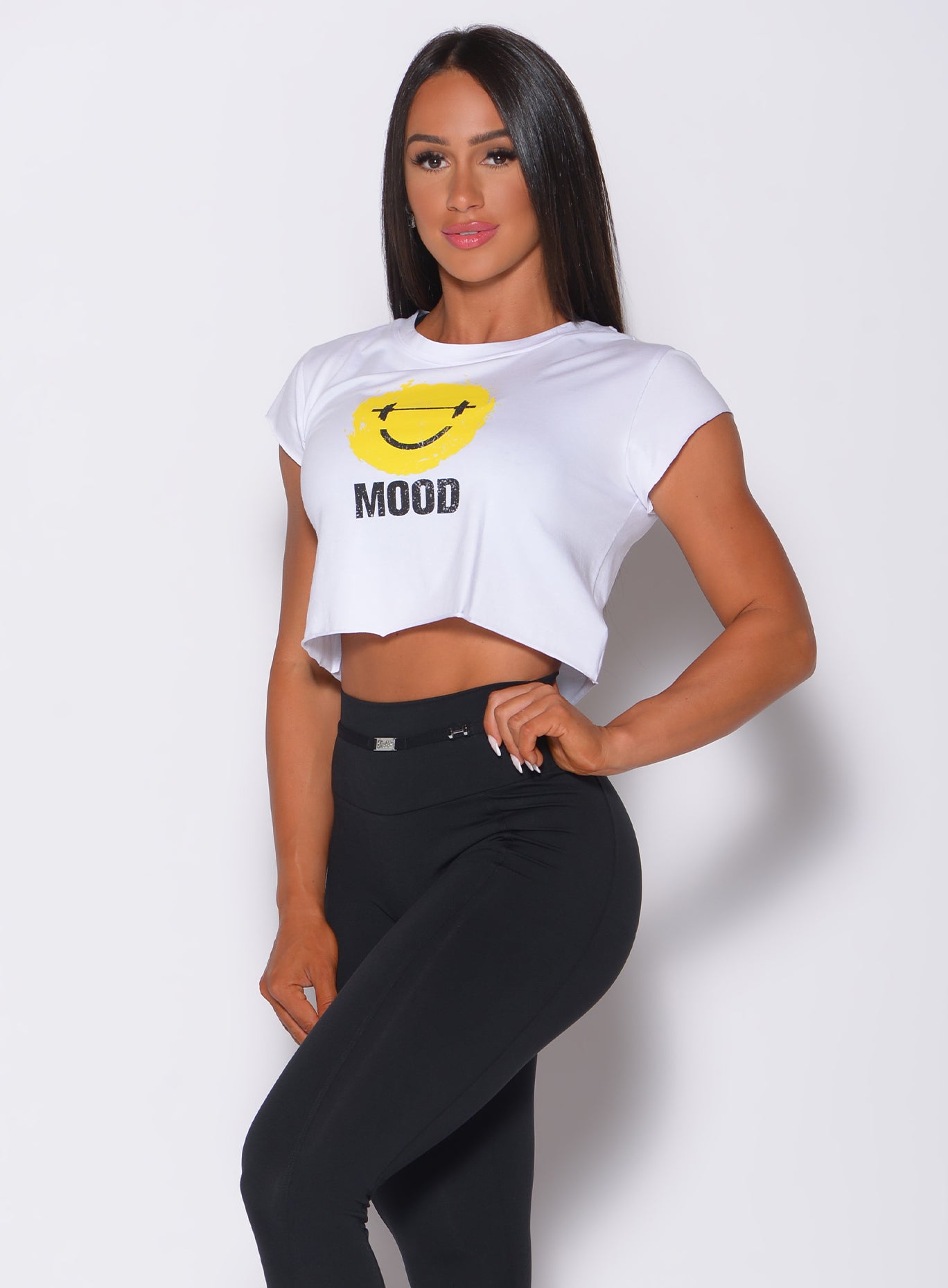 Front profile view of a model wearing  our white mood tee and a black leggings