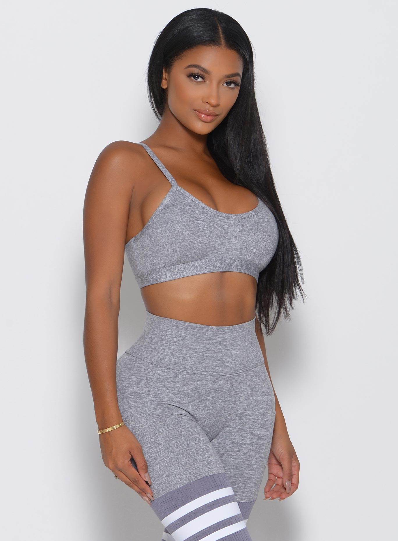 Model facing forward in a gray sports bra and a high waisted matching leggings 