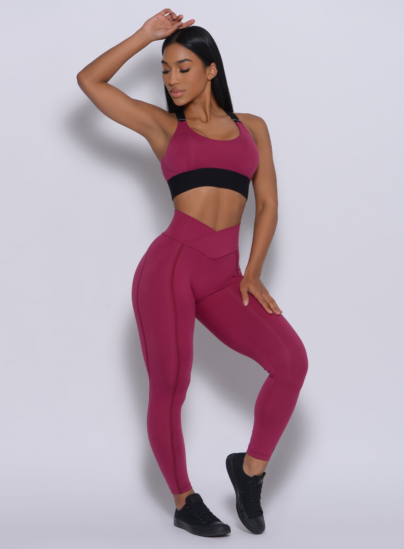 Front profile  view of the model wearing our Brazilian leggings in mulberry color and a matching bra