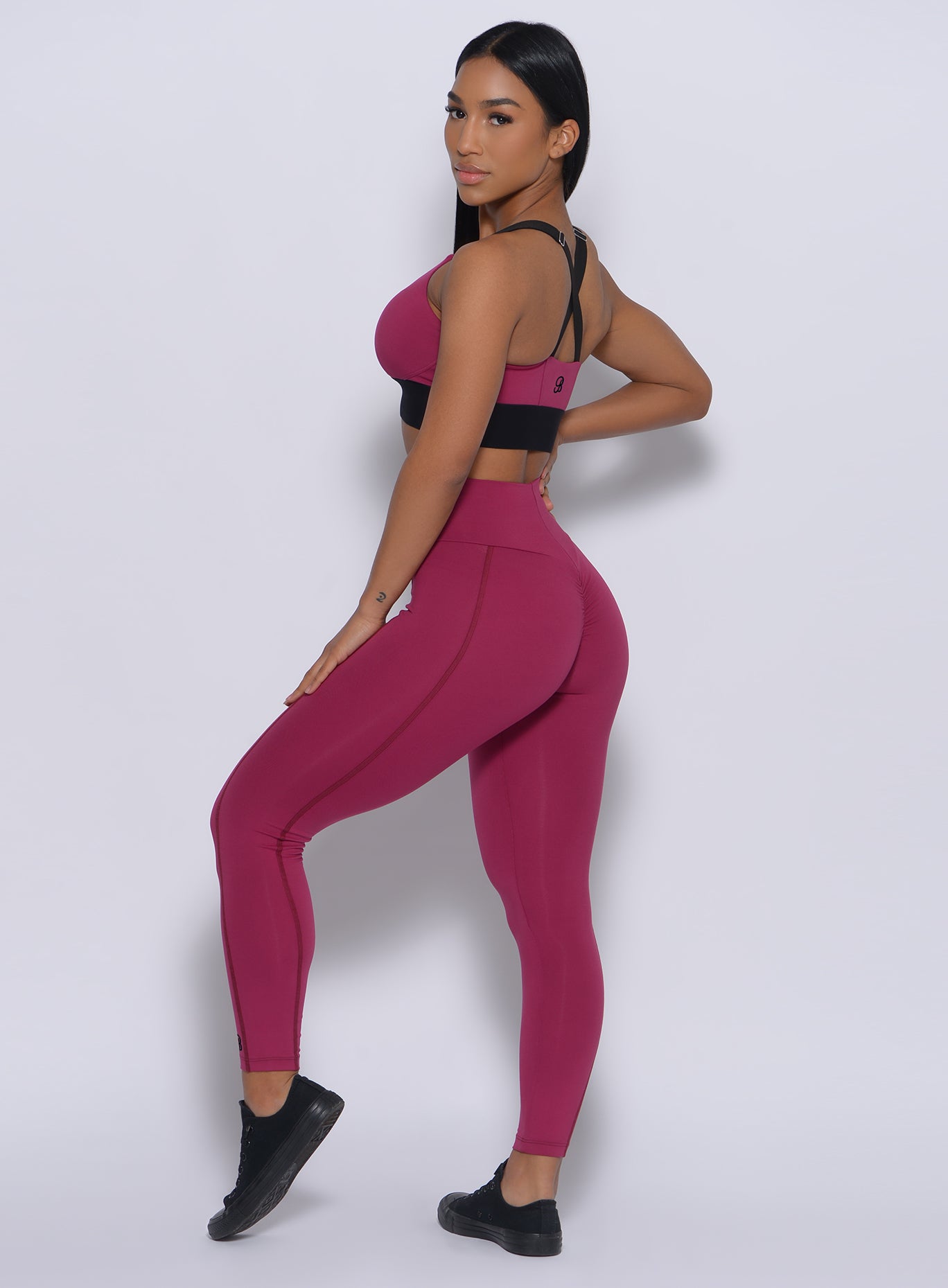 Left side  view of the model in our Brazilian leggings in mulberry color and a matching bra