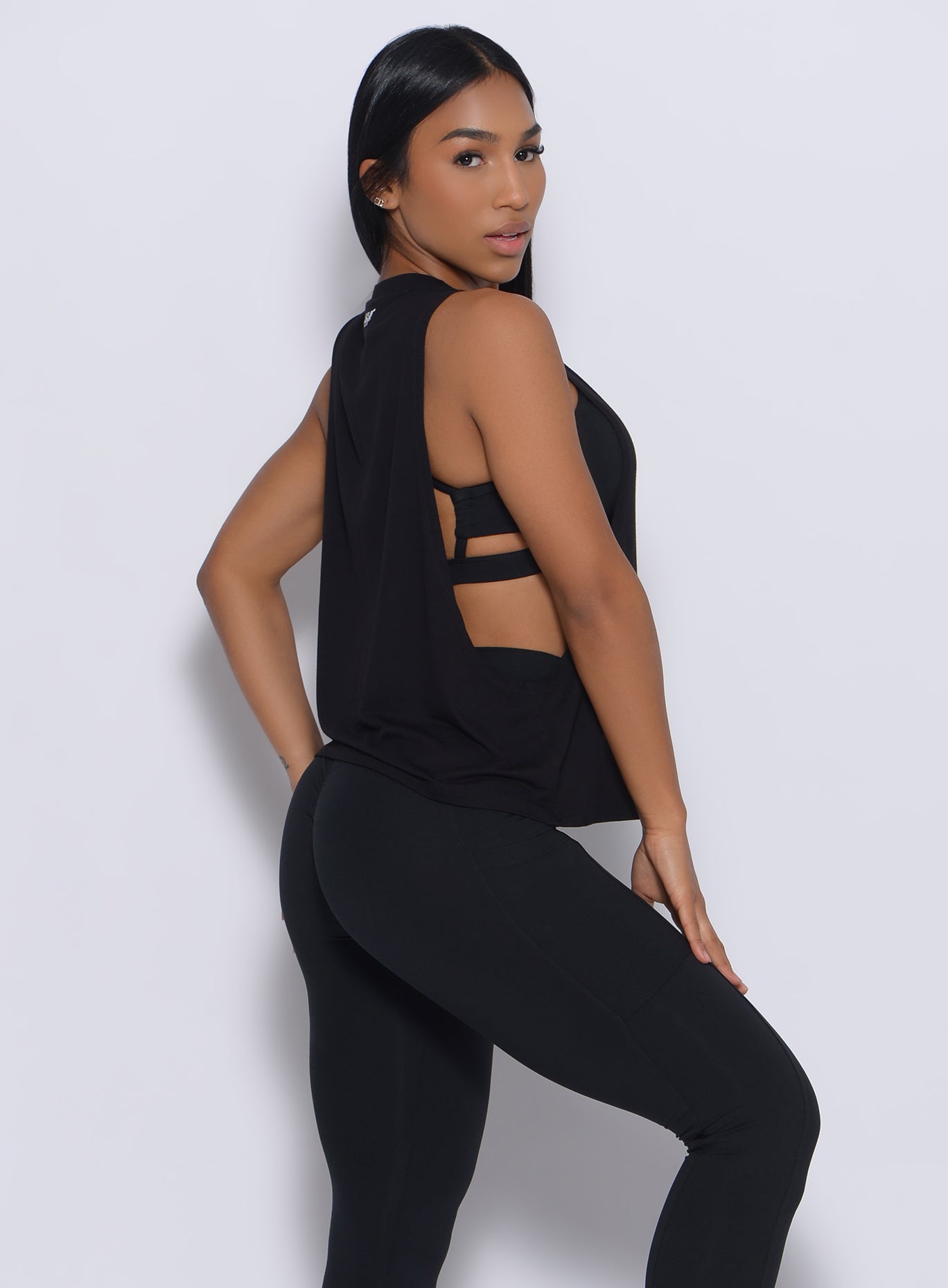 Right side profile view of a model in our black muscle tank and a matching leggings