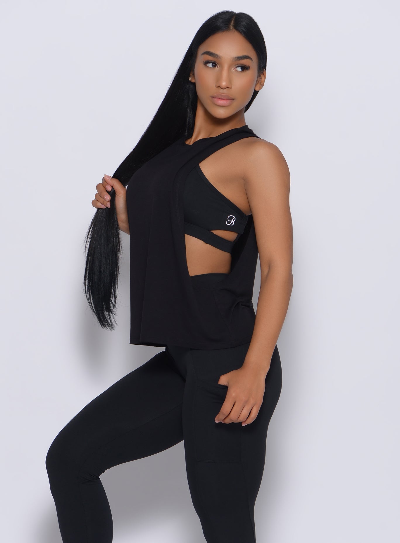 Left side view of a model in our black muscle tank and a matching leggings 