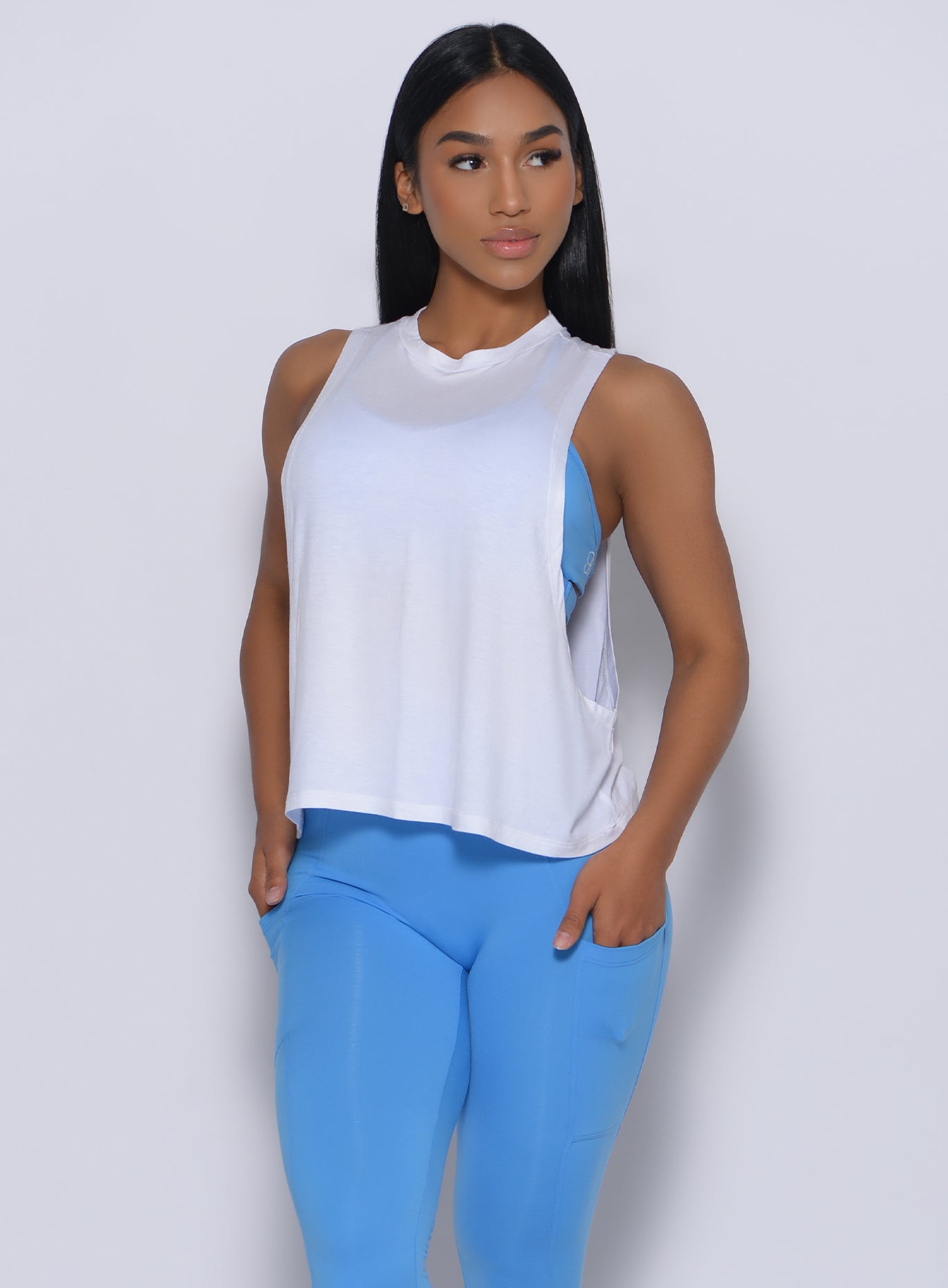 Front profile view of a model in our white muscle tank and a blue leggings