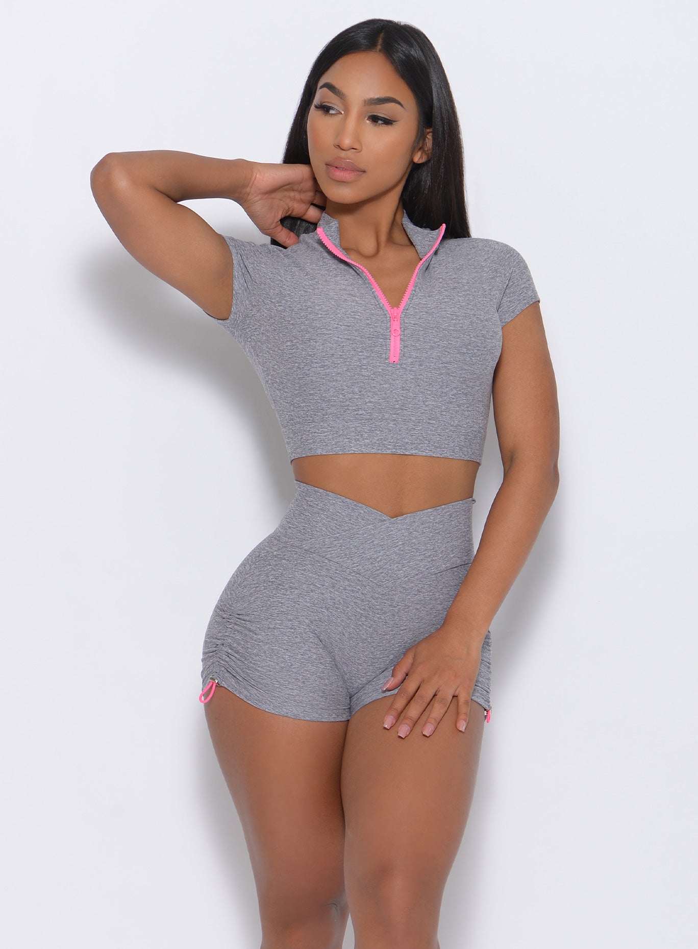 Front view of the model in our neon zip top in cloud color and a matching shorts 