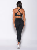 Back profile view of a model wearing our black toggle leggings and a matching sports bra 