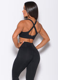 Back side profile view of a model in our black toggle sports bra and a matching leggings