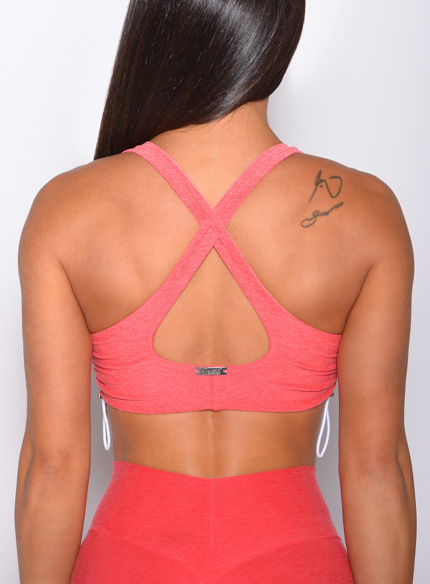 Zoomed in back view of our toggle sports bra in Ombre Fiji Coral